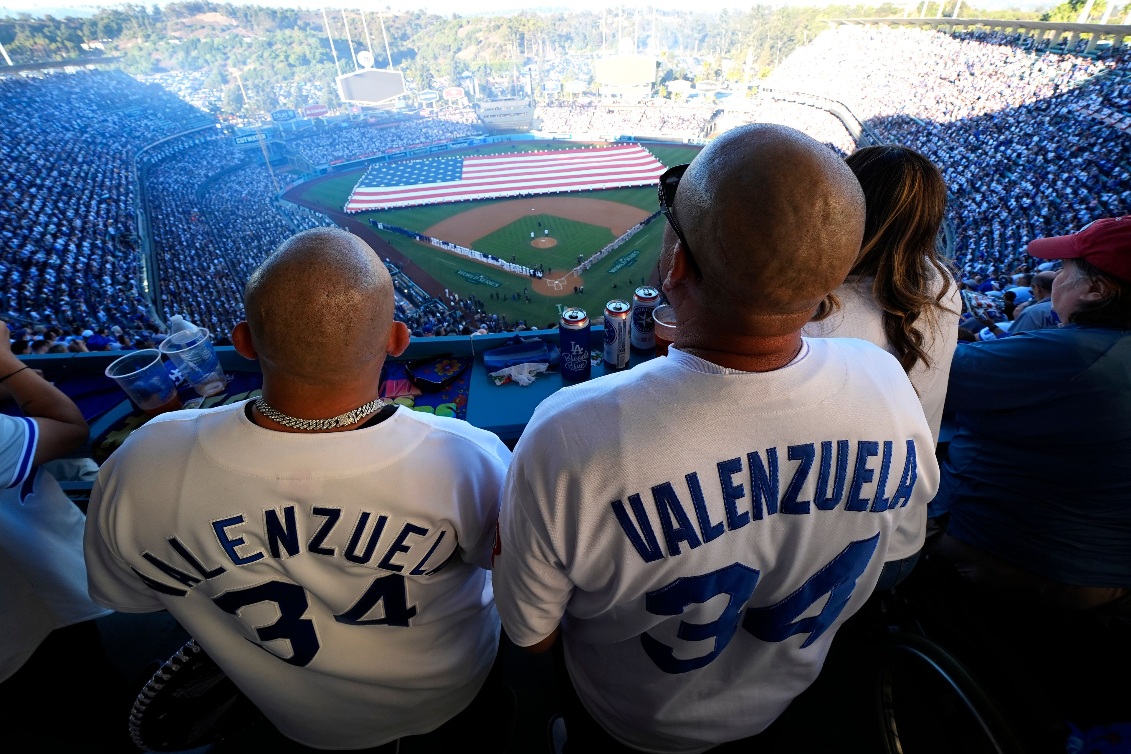 Fans stand during the national antehm before Game 1 of the baseball World Series, Friday, Oct. 25, 2024, in Los Angeles. (AP Photo/Julio Cortez)