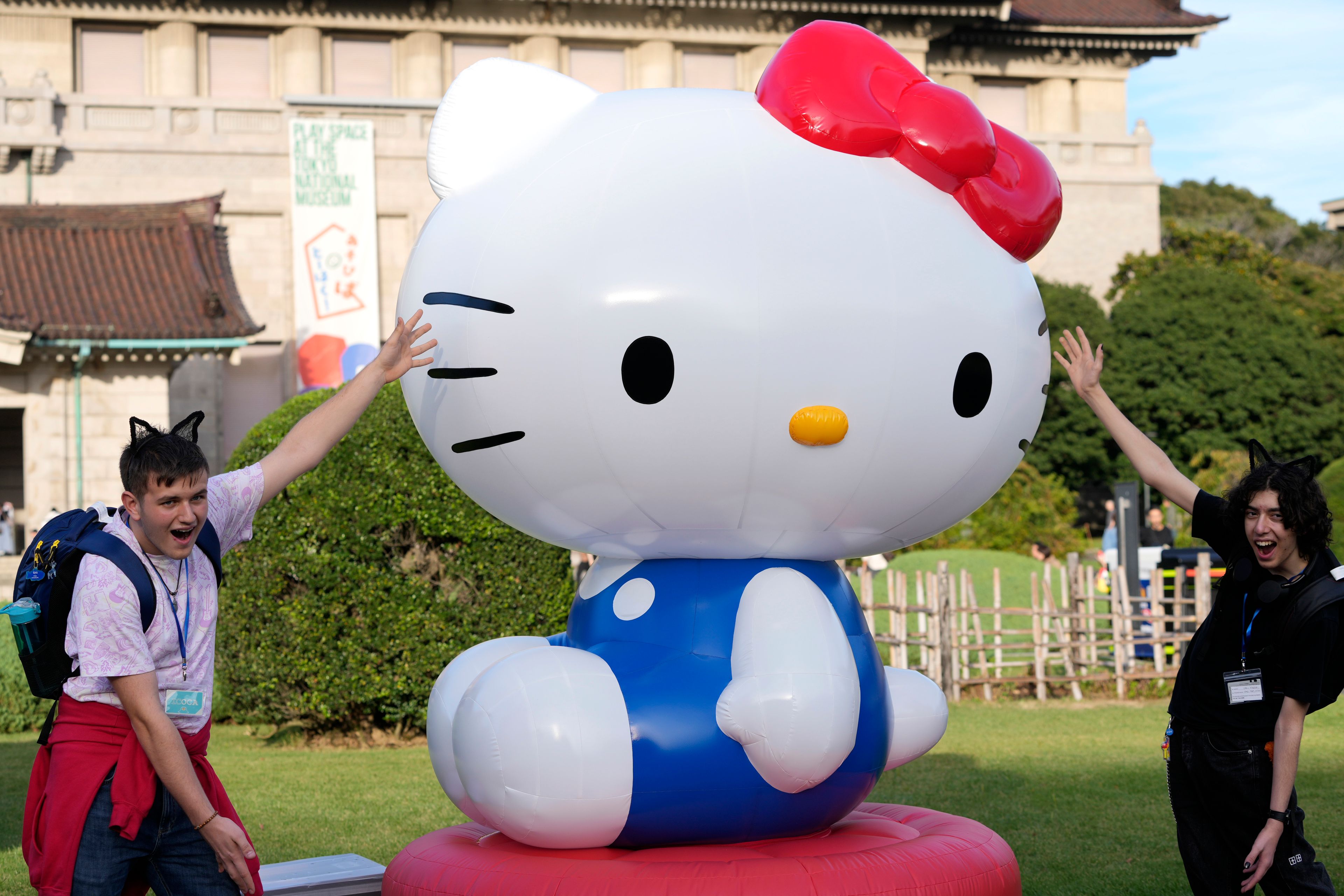 Tourists from Britain pose with Hello Kitty decoration at the Tokyo National Museum where the exhibition "As I change, so does she" is held, marking the 50th anniversary of Hello Kitty in Tokyo Wednesday, Oct. 30, 2024. (AP Photo/Shuji Kajiyama)