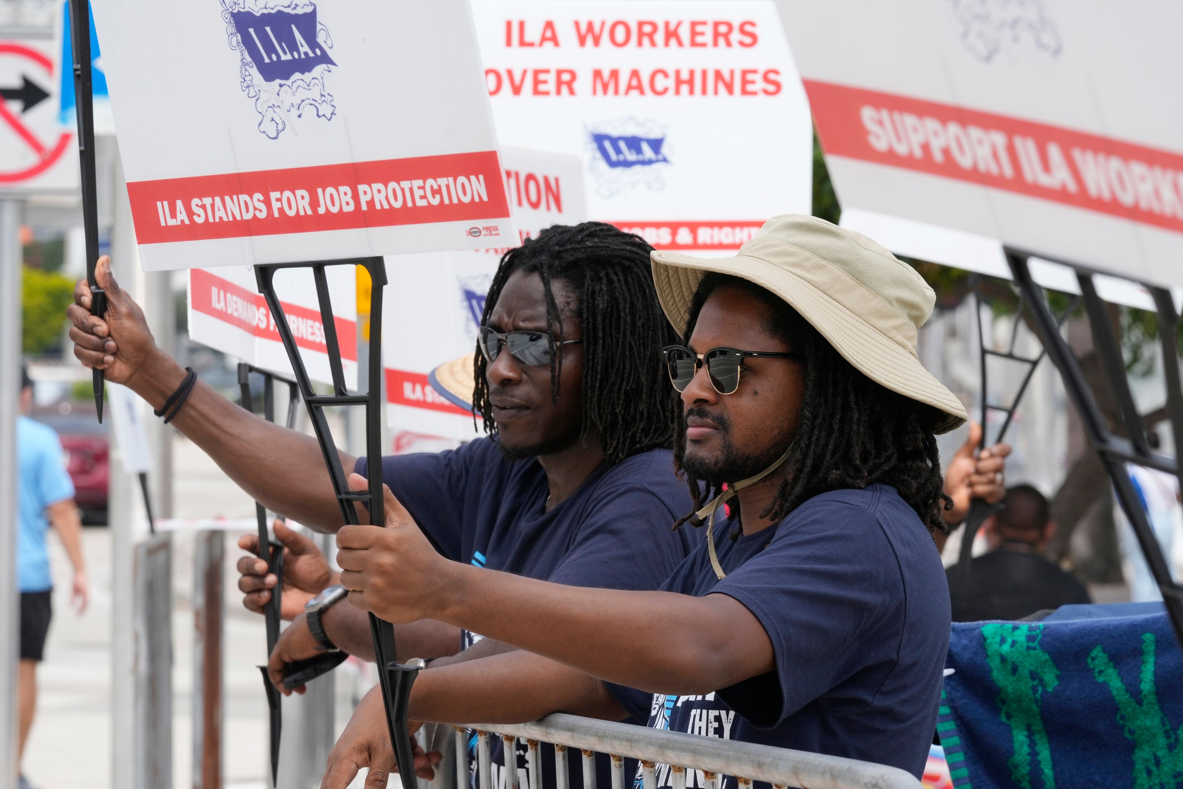 Dockworkers from Port Miami display signs at a picket line, Thursday, Oct. 3, 2024, in Miami. (AP Photo/Marta Lavandier)