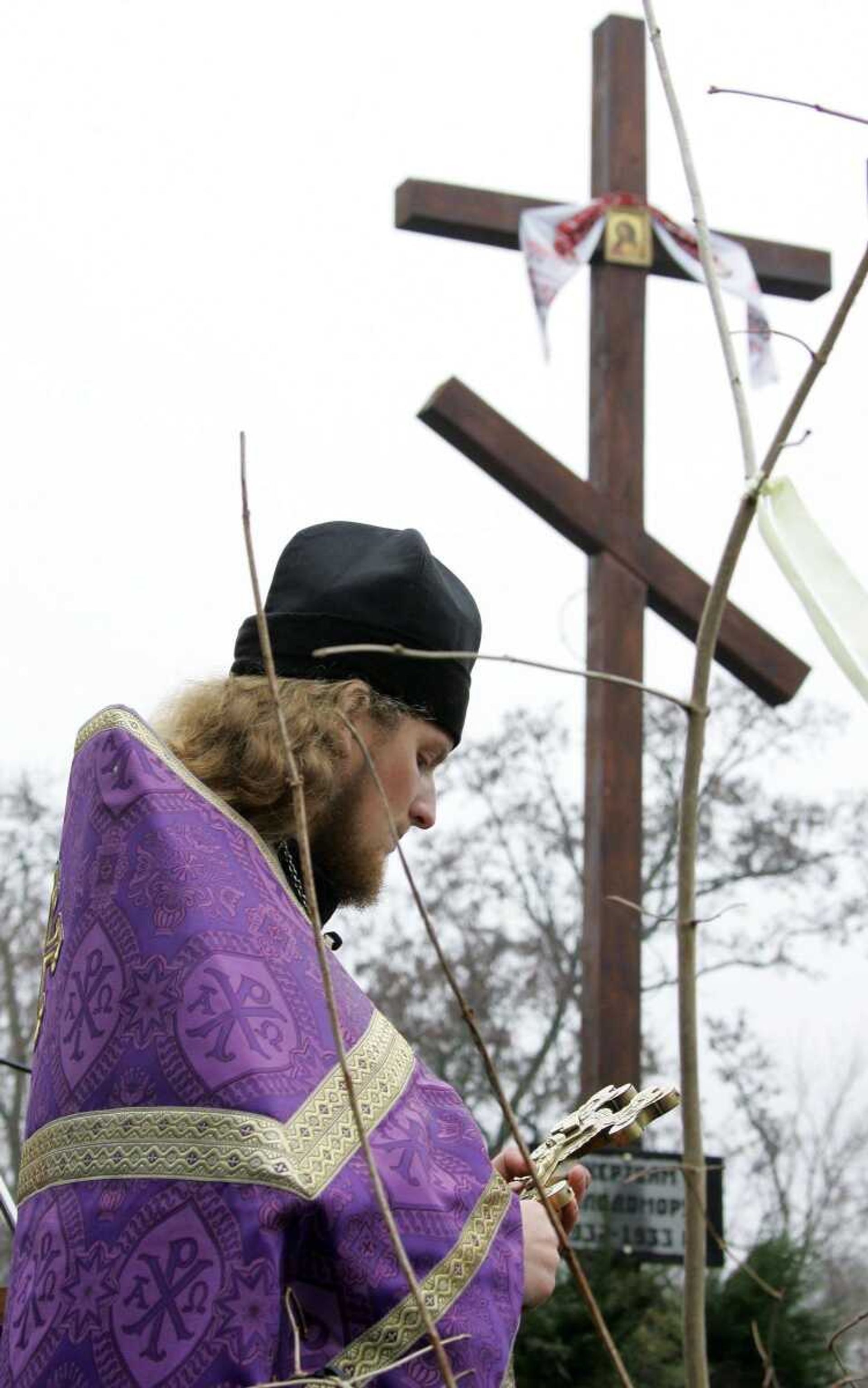 An Orthodox priest stood at the monument to Soviet-era famine victims during a commemorative ceremony in the village of Sehiyvka, in the Cherhinivsky region of Ukraine on Friday. (MYKOLA LAZARENKO ~ Presidential Press Service)