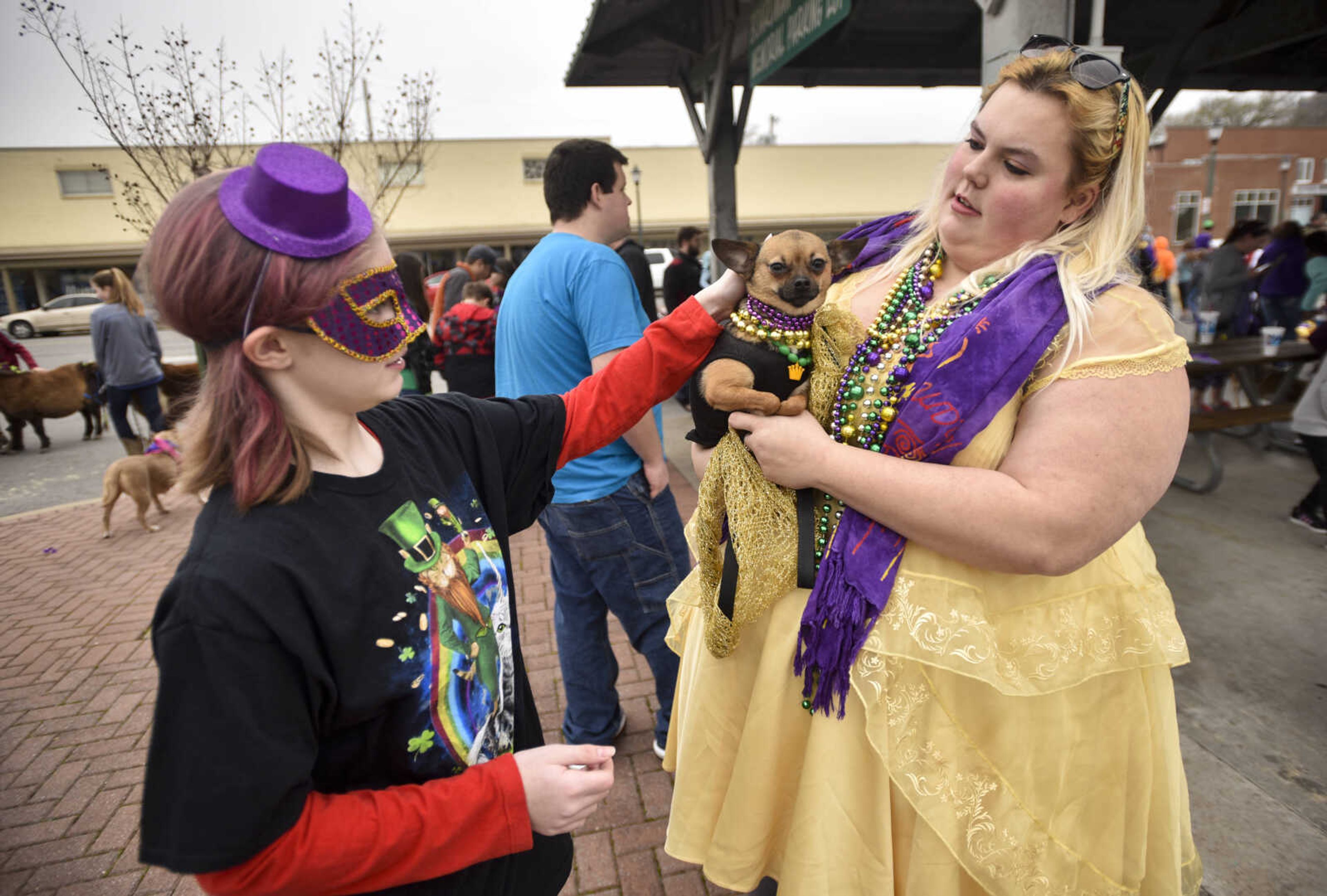 Kendra Goodman, 13, pets Kim Stovall's dog Suzie Q, a pug/chihuahua mix, before the 2nd annual Mardi Paws Parade of Pets begins Sunday, March 18, 2018, in Cape Girardeau.