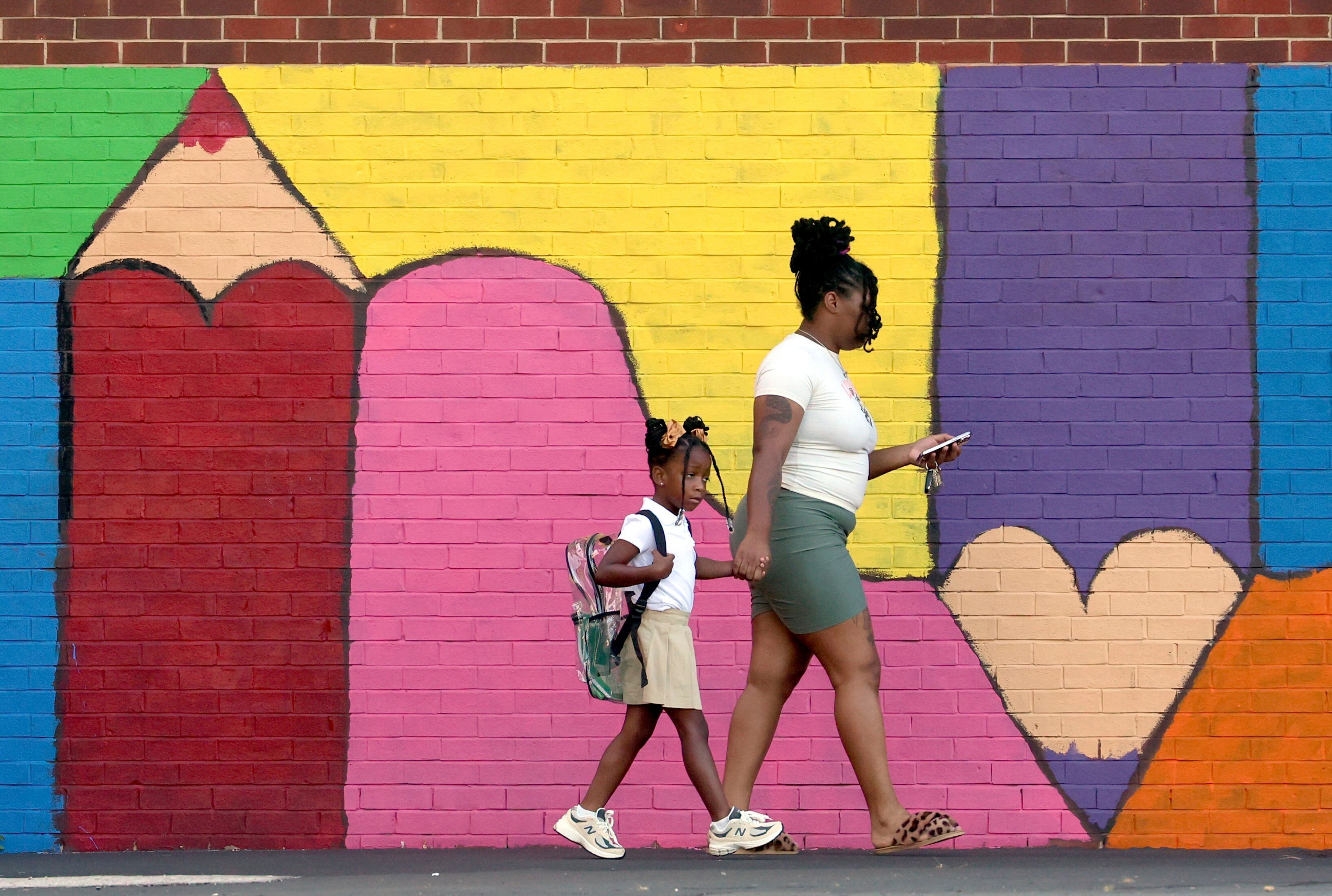 FILE - Bria Gibbs brings her daughter Tai'la Harris, 4, into Columbia Elementary school for the first day of classes for St. Louis Public Schools on Monday, Aug. 19, 2024. Gibbs drove her daughter to school. (David Carson/St. Louis Post-Dispatch via AP, File)