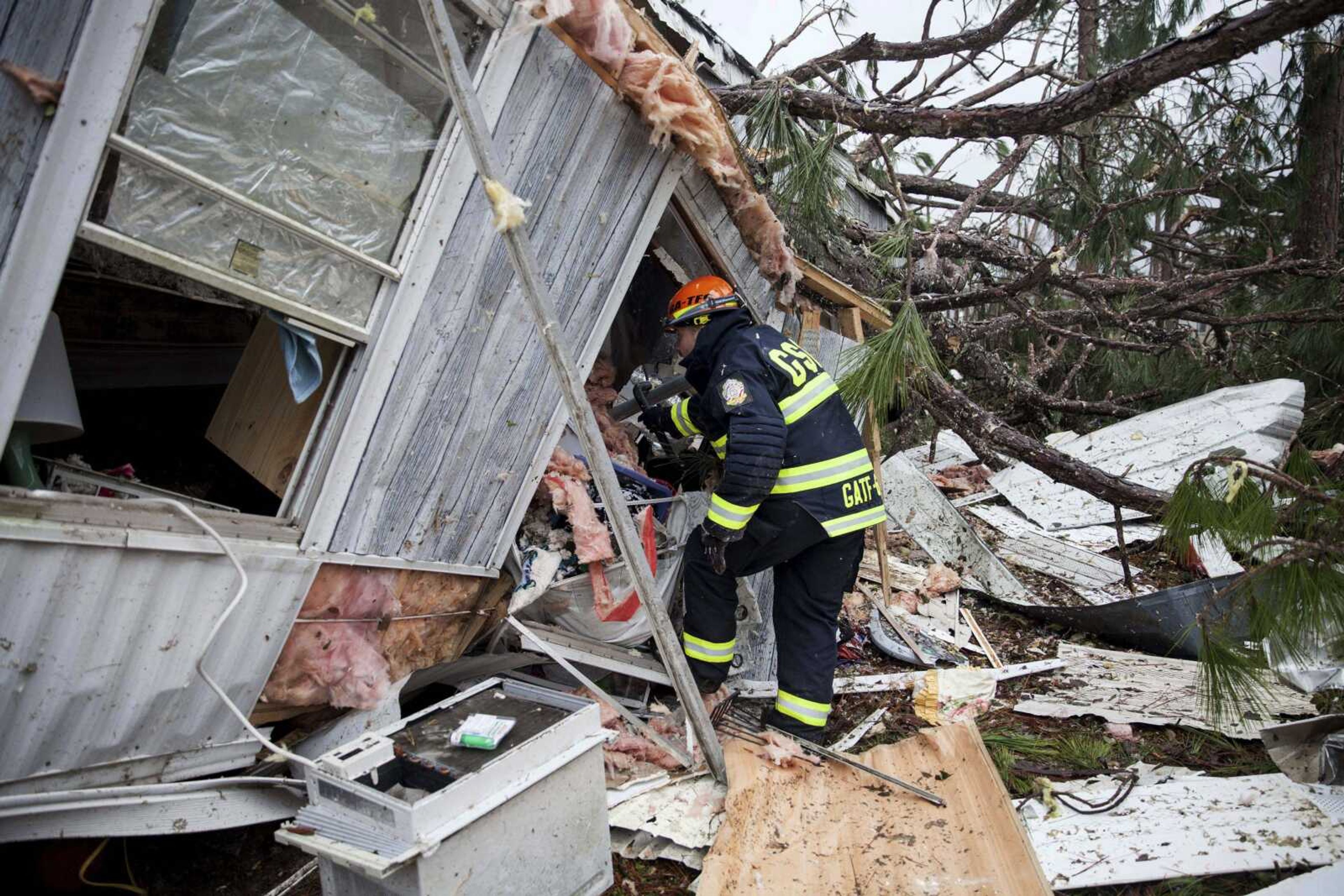 A rescue worker enters a hole in the back of a mobile home Monday in Big Pine Estates that was damaged by a tornado in Albany, Georgia. Fire and rescue crews were searching through the debris, looking for people who might have become trapped when the deadly storm came through.