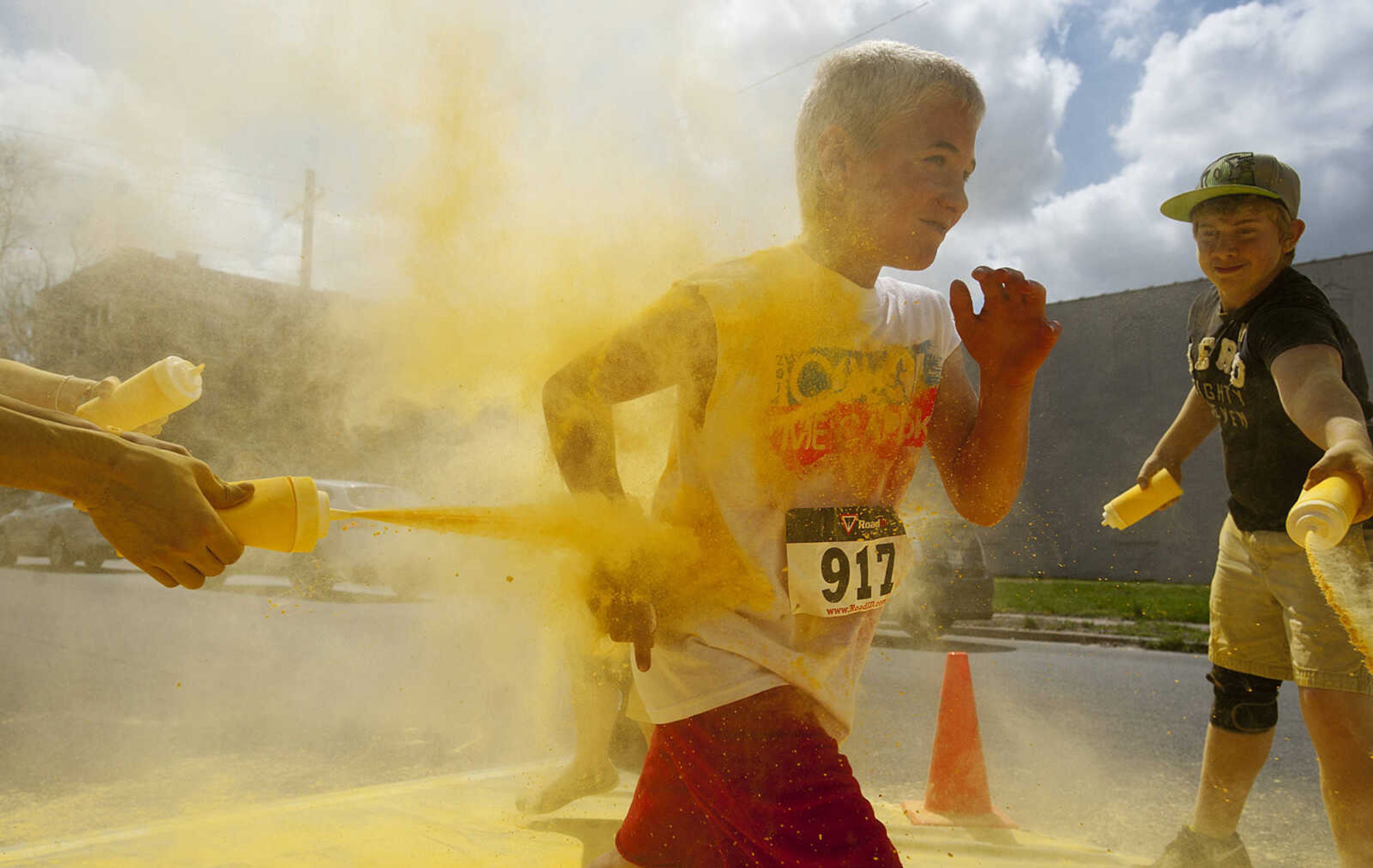 ADAM VOGLER ~ avogler@semissourian.com
Participants in the Color Me Cape 5k run through the yellow color station north of the intersection of Independence Street and Frederick Street Saturday, April 12, in Cape Girardeau.