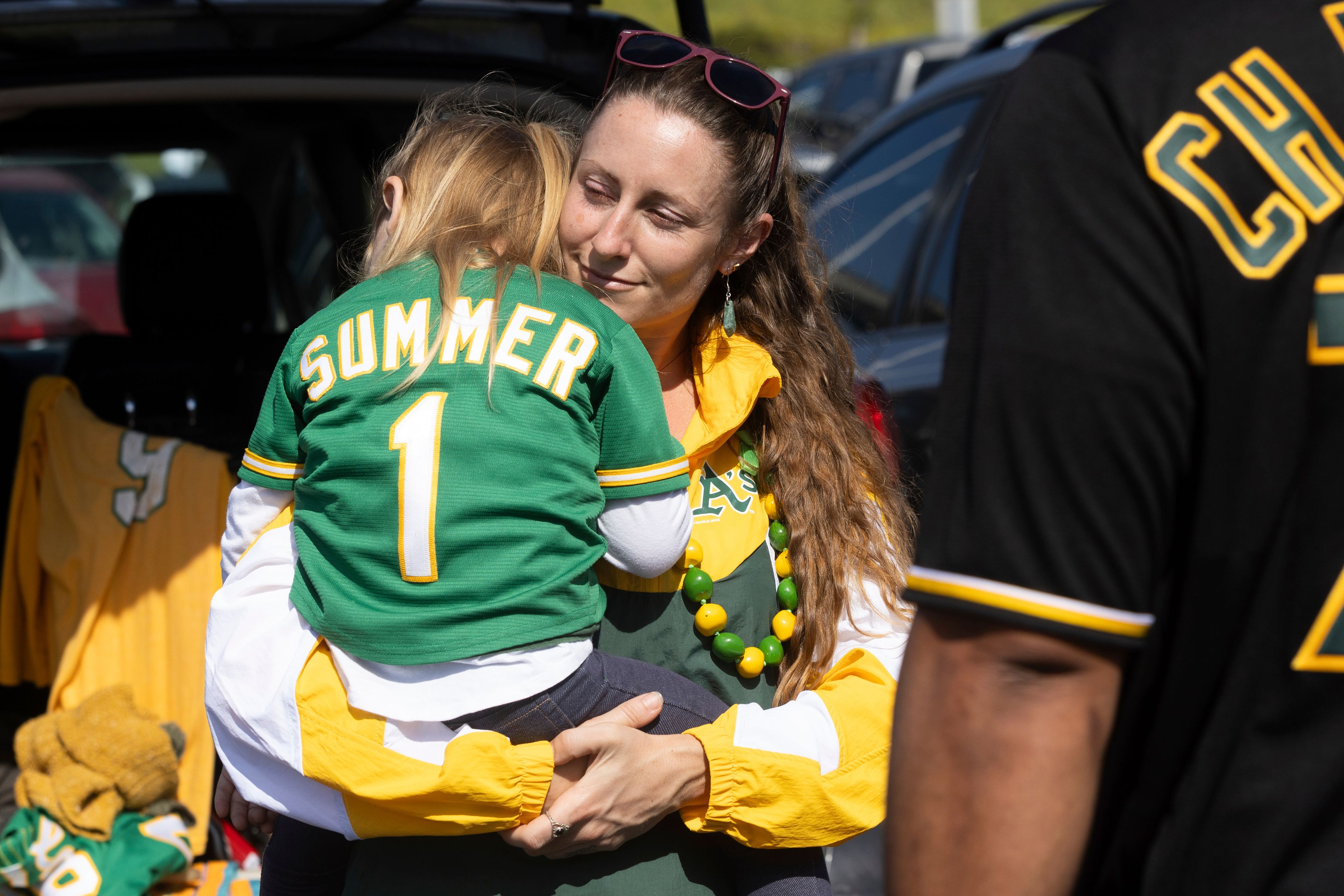 Marta Sutter holds her daughter, 3-year-old Summer Sutter outside the Oakland Coliseum before a baseball game between the Oakland Athletics and the Texas Rangers Thursday, Sept. 26, 2024, in Oakland, Calif. (AP Photo/Benjamin Fanjoy)