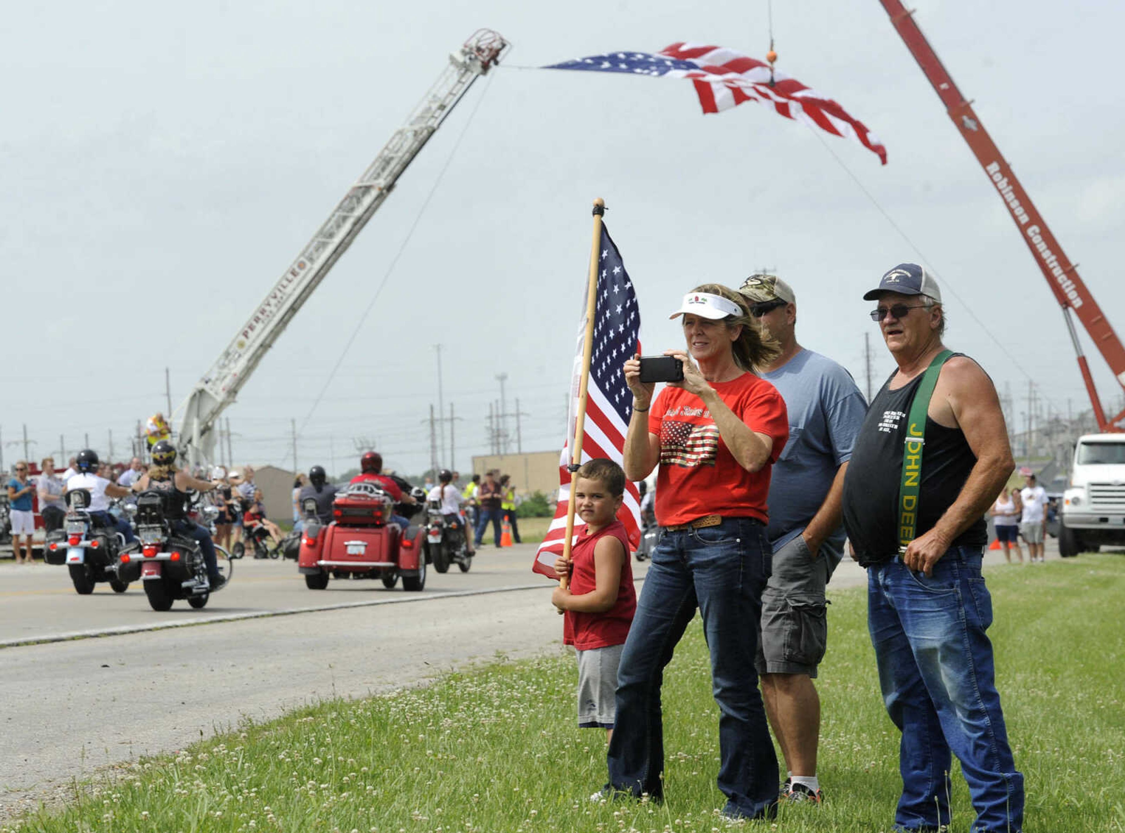 People watch the parade of motorcyclists at the arrival of The Wall That Heals on Tuesday, June 17, 2014 in Perryville, Mo.