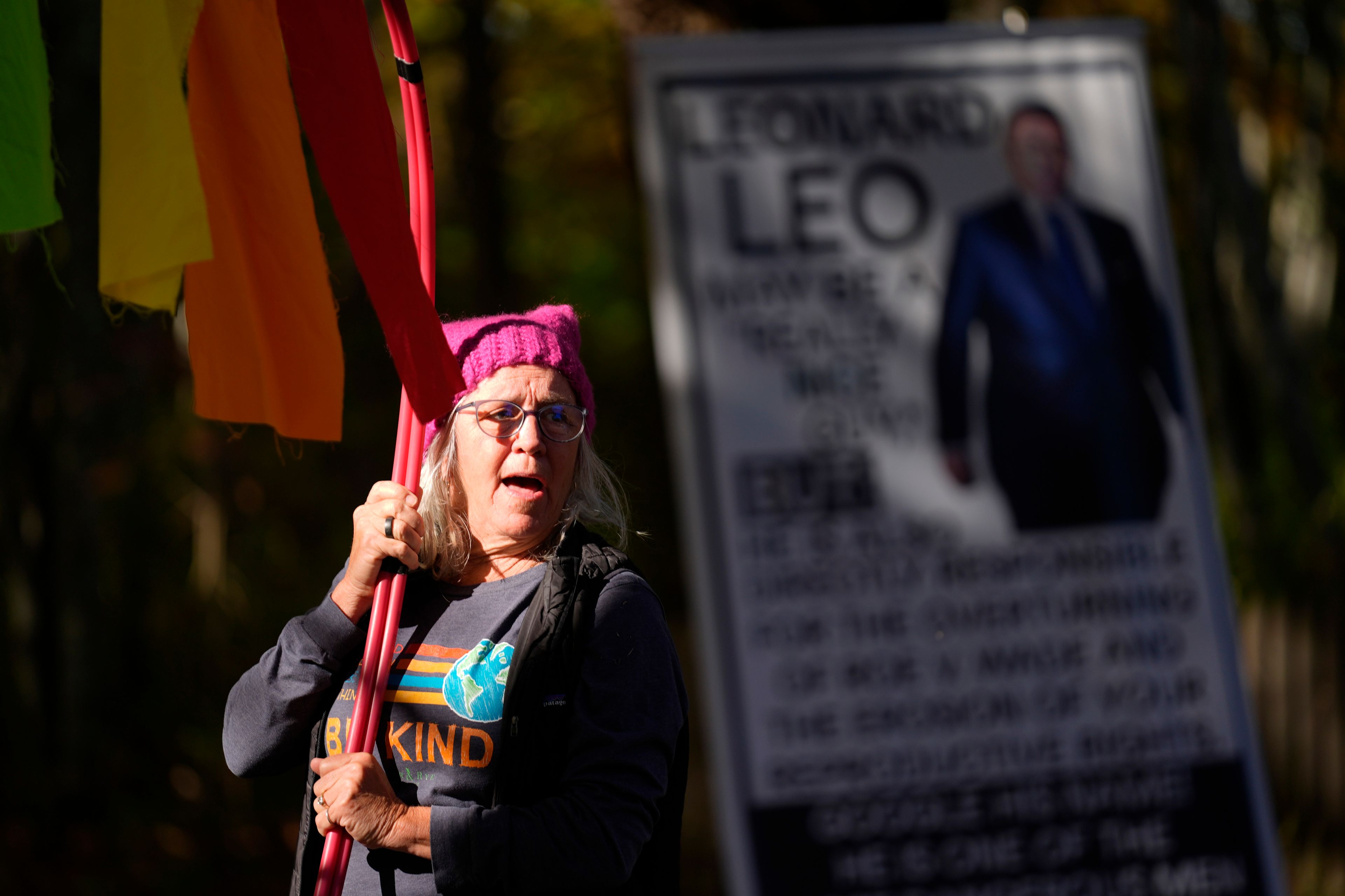 Sheila Eddison protests in front of the home of Leonard Leo during the Mount Desert Island Marathon, Sunday, Oct. 20, 2024, in Northeast Harbor, Maine. (AP Photo/Robert F. Bukaty)