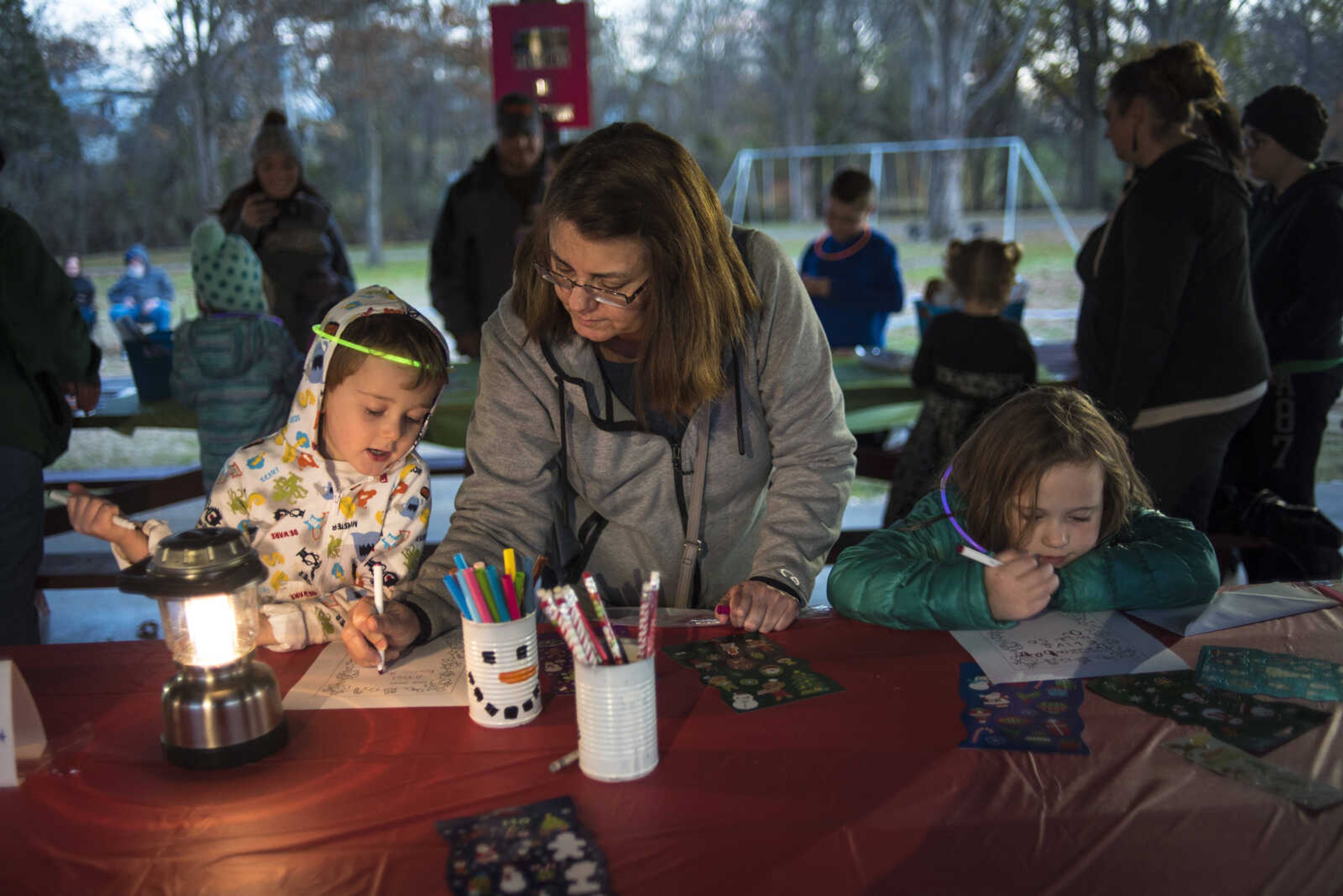 Debbie Garner, center, helps out Colton Roark, 4, left, and Willow Roark, 6, with letters to Santa during the Jackson Holiday Extravaganza Friday, Nov. 24, 2017 at the Jackson City Park.