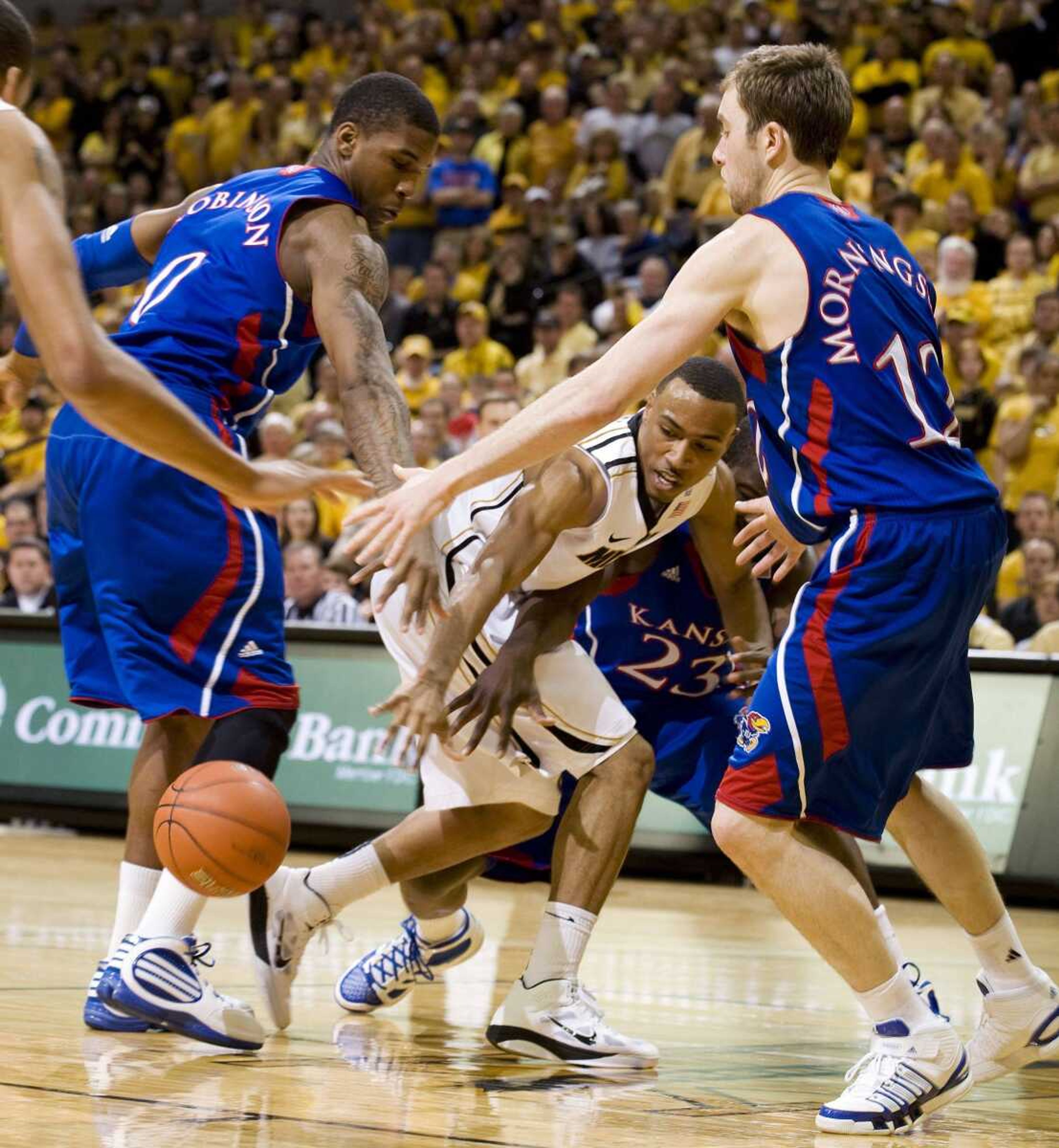 Missouri's Matt Pressey, center, passes the ball between two Kansas defenders during the second half Saturday.