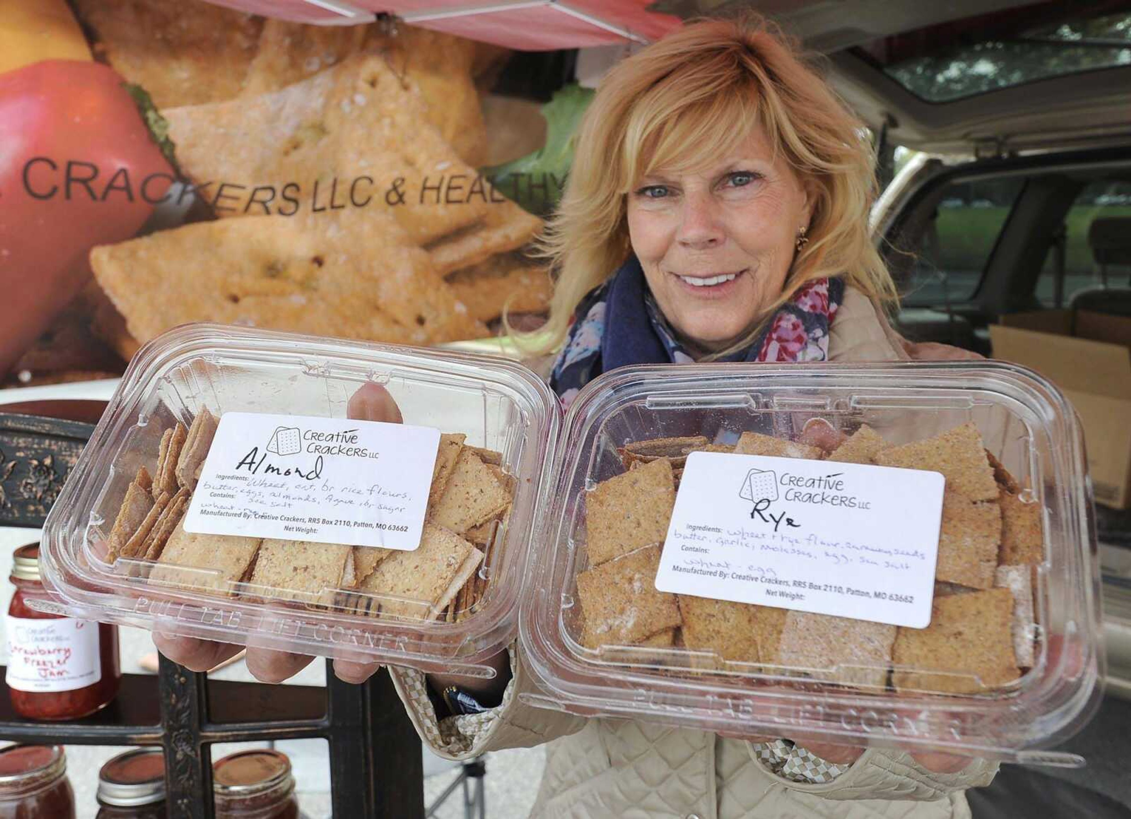 Nancy Mayfield, owner of Creative Crackers LLC, shows two varieties Thursday at the Cape Farmers Market.