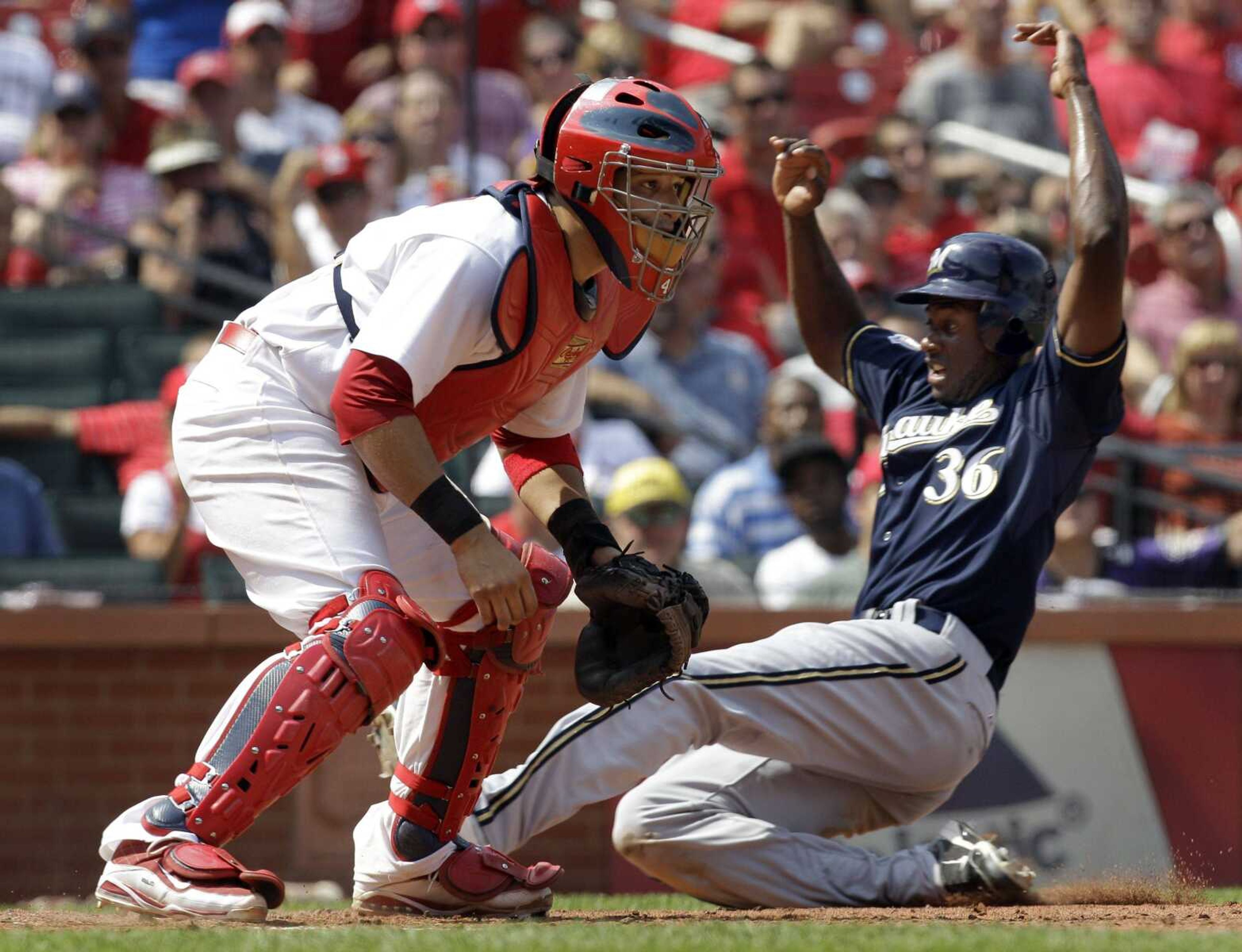 Brewers base runner Lorenzo Cain scores on a sacrifice fly as Cardinals catcher Yadier Molina waits for the throw during the seventh inning Wednesday in St. Louis. (JEFF ROBERSON ~ Associated Press)