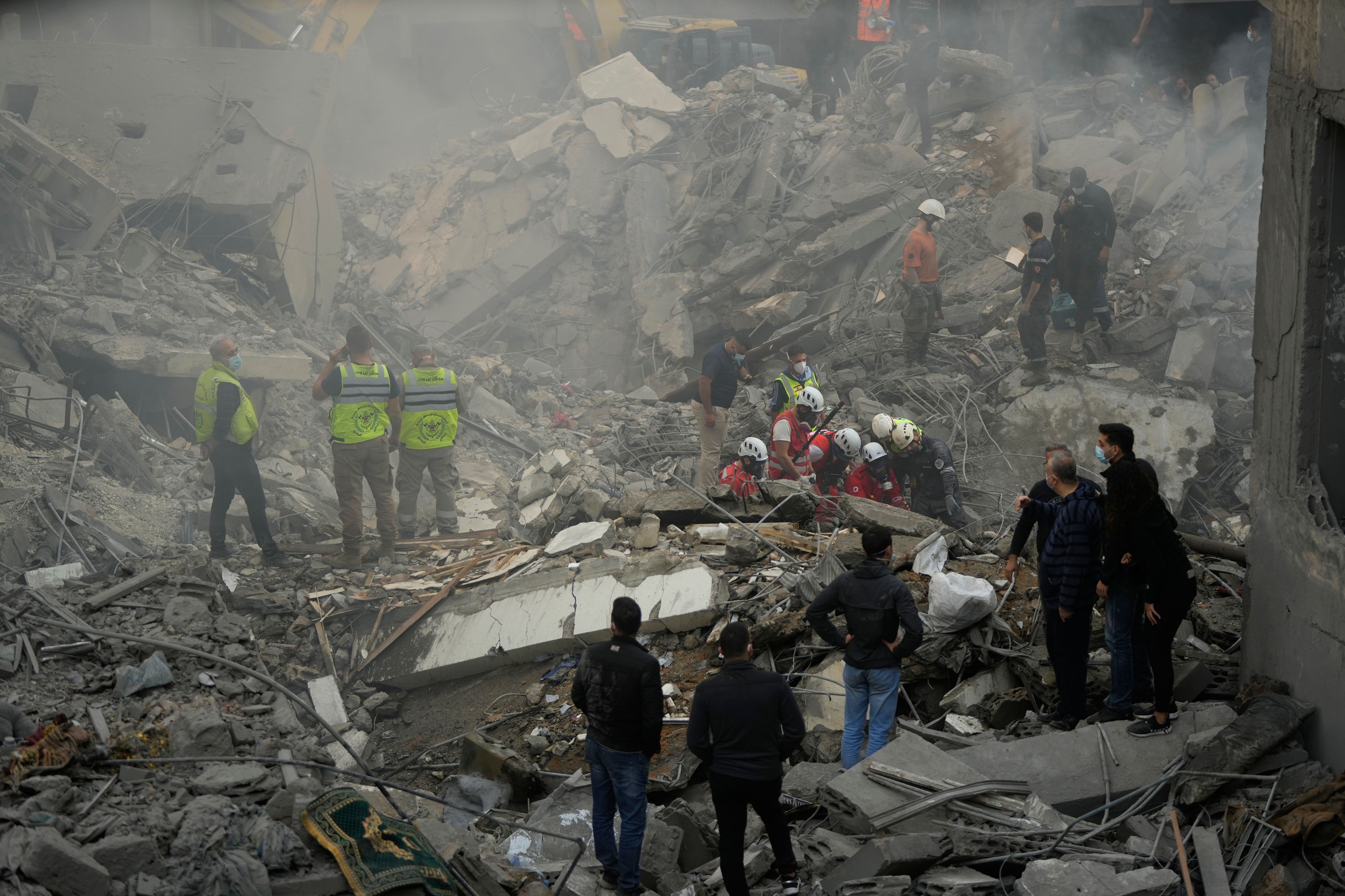 Rescue workers and people search for victims at the site of an Israeli airstrike that hit central Beirut, Lebanon, Saturday, Nov. 23, 2024. (AP Photo/Hassan Ammar)