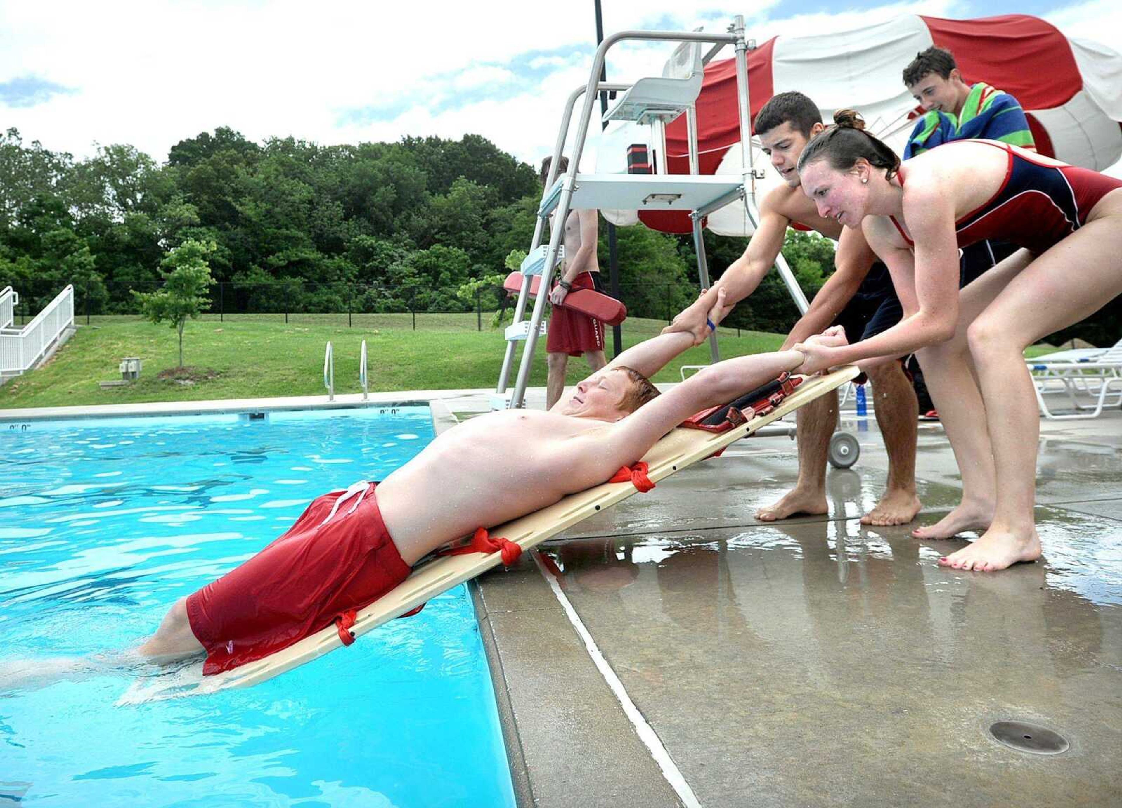 Tyler Middleton and Sierra Smith pull Christian Retter out of the pool using a backboard Thursday at Cape Splash in Cape Girardeau. Middleton, Smith and Retter were training in passive extraction as part of their water park certification. (Laura Simon)