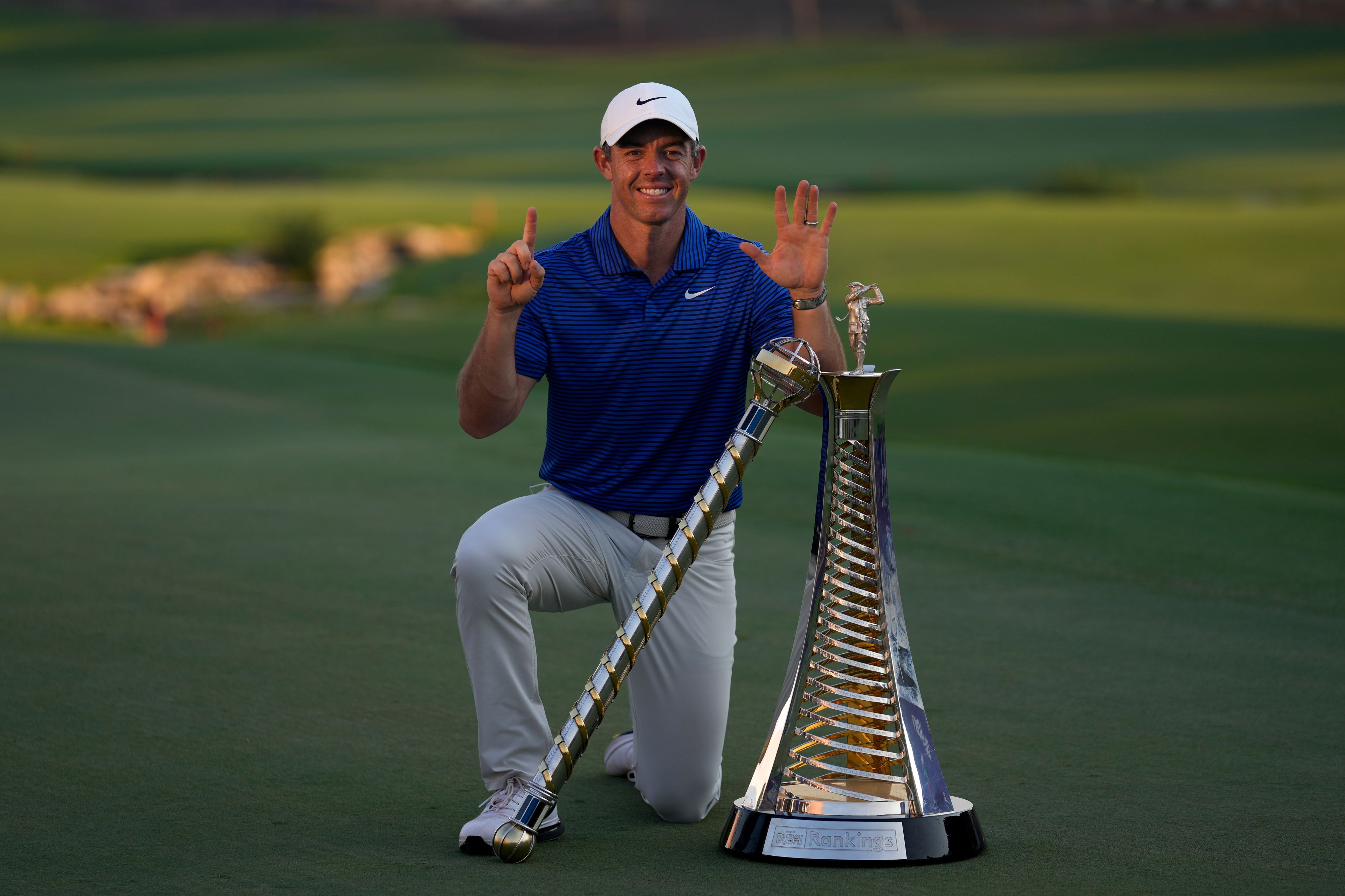 Rory McIlroy of Northern Ireland poses with the DP World Tour Championship trophy and the Race to Dubai trophy after winning the World Tour Golf Championship in Dubai, United Arab Emirates, Sunday, Nov. 17, 2024. (AP Photo/Altaf Qadri)