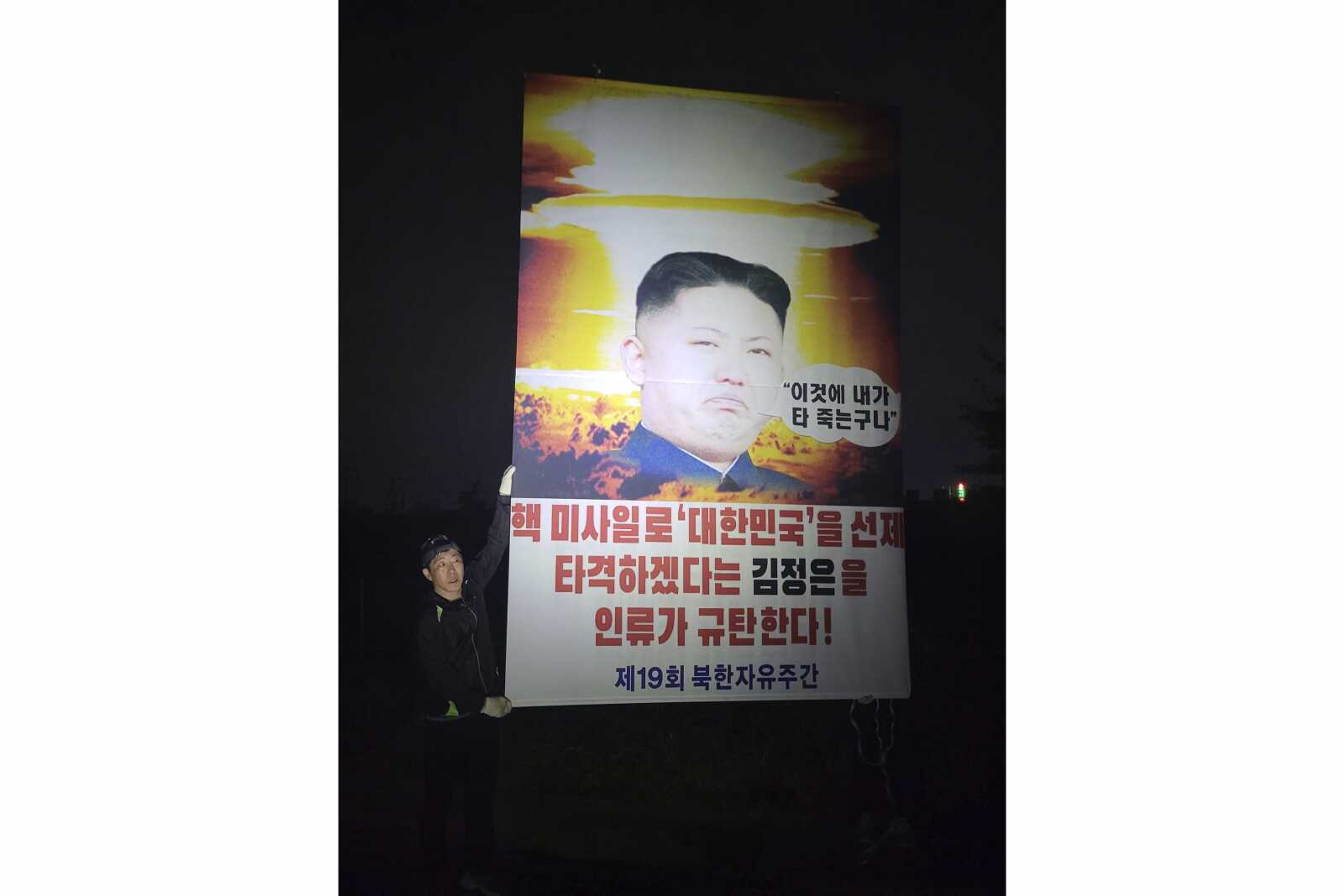 Park Sang-hak, a North Korean defector-turned-activist, holds a placard condemning North Korean leader Kim Jong Un on Saturday in the border town of Paju, South Korea. South Korean activists say they clashed with police while launching balloons carrying anti-Pyongyang propaganda materials across the North Korean border, ignoring their government's plea to stop such activities as the North has threatened to respond with "deadly" retaliation. The signs read "Entire humanity denounces Kim Jong Un who threatens to preemptively strike with nuclear missiles."