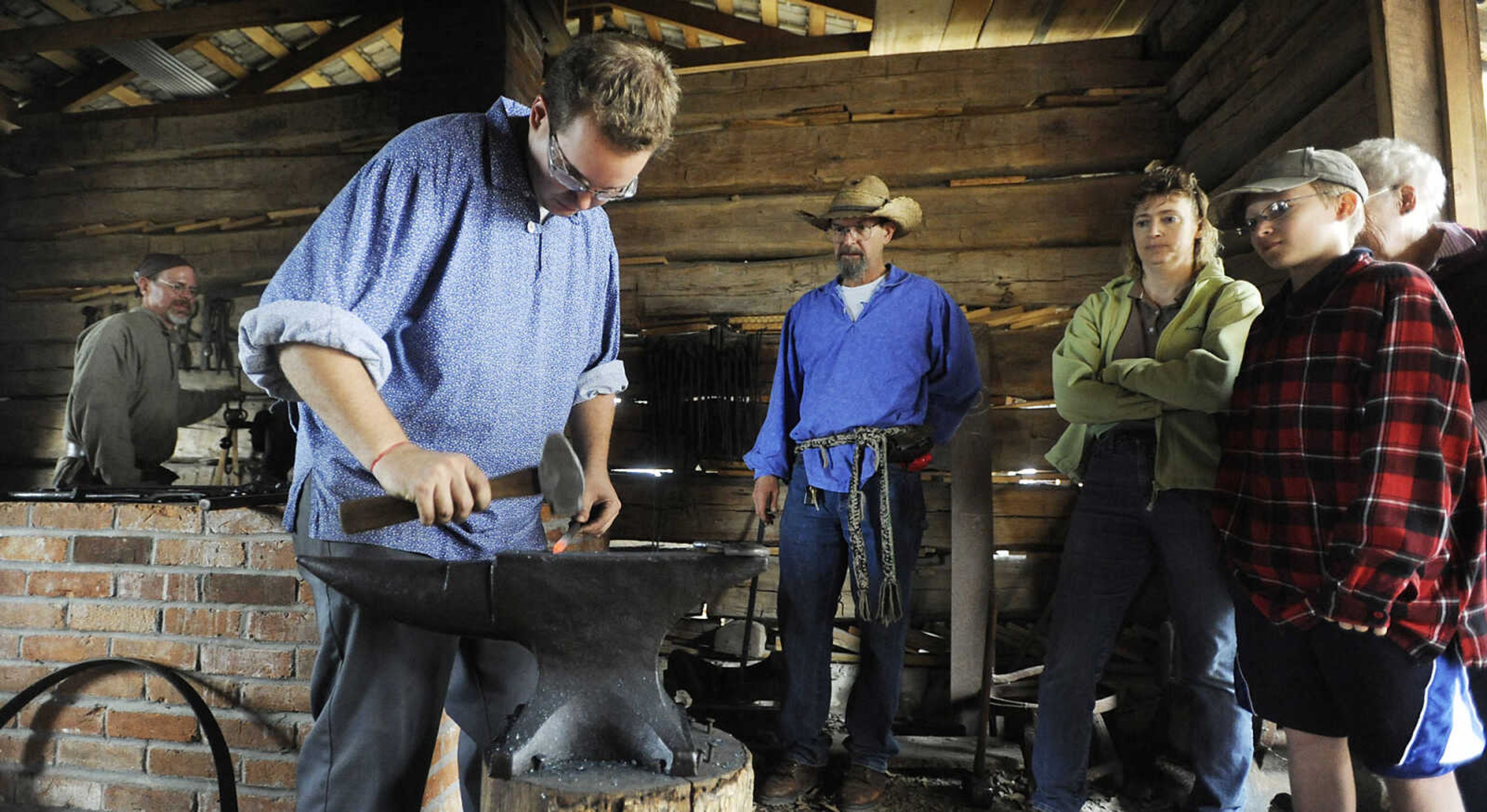 Blacksmiths Ian Willie, front, and Mark Petzoldt, left, make nails as visitors look on at the Saxon Lutheran Memorial's Fall Festival Saturday, October 13, in Frohna. The annual festival celebrates the heritage of the area's 19th century German immigrants.