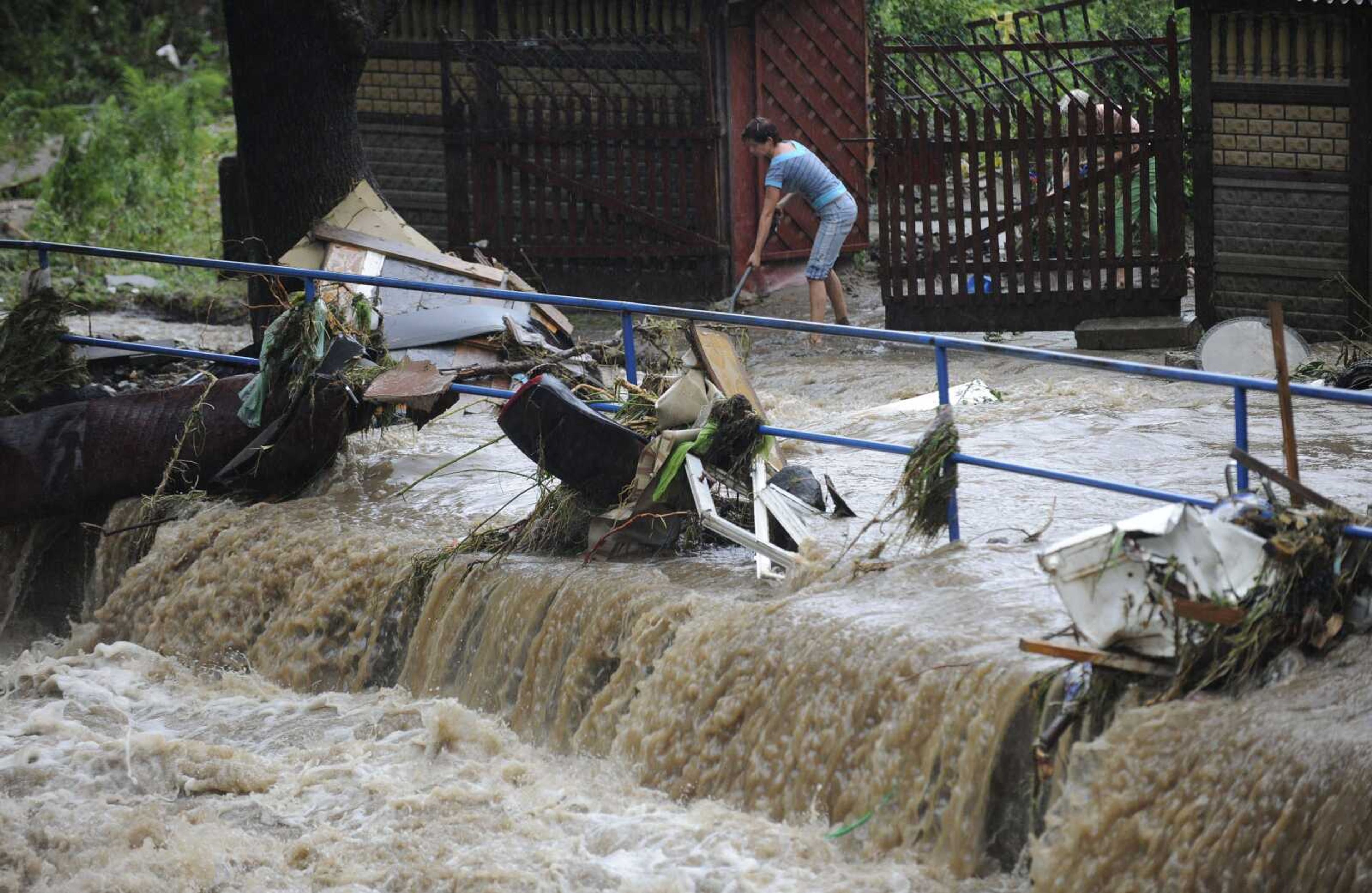 Residents walk among the debris following flooding in Bogatynia, Poland, on Saturday Aug. 7, 2010. The floods struck late Friday but worsened on Saturday, leaving three-fourths of the southwestern Polish town of Bogatynia inundated after the Miedzianka River spilled its banks. (AP Photo/Robert Steiner ) **POLAND OUT**