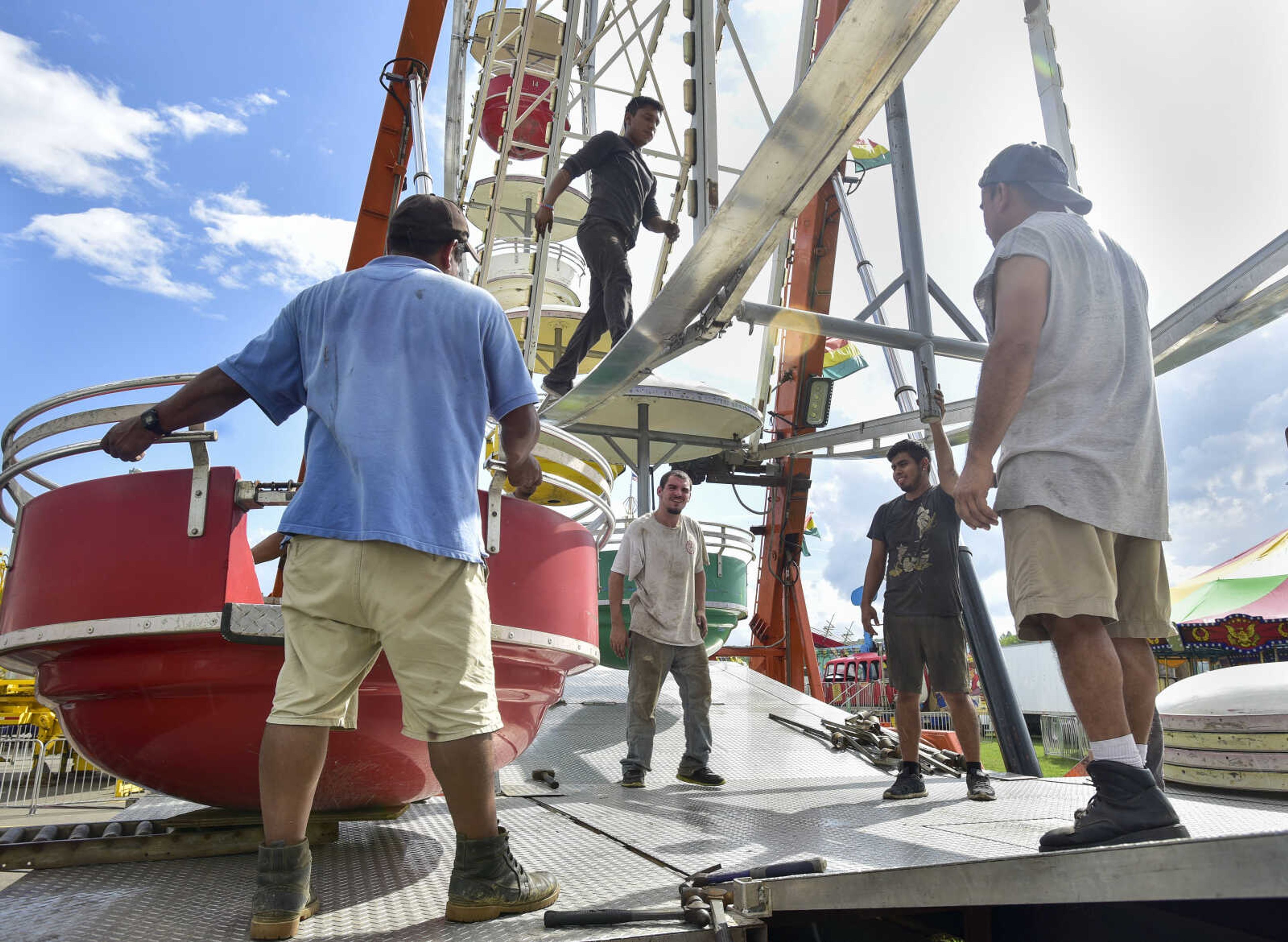 Carnival workers unload a passenger car as they construct a ferris wheel at the SEMO District Fairgrounds Thursday, Sept. 6, 2018, in Cape Girardeau.