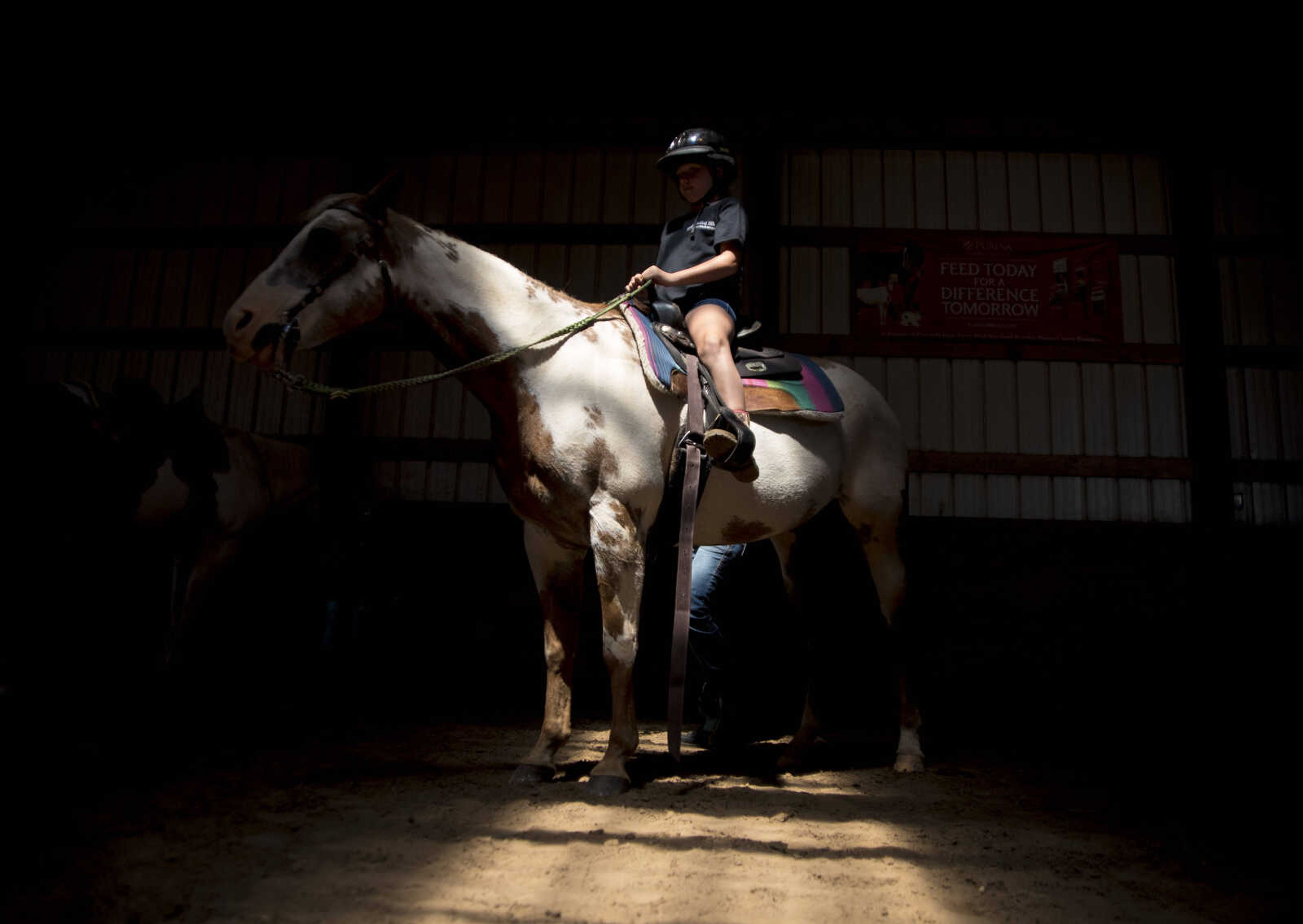 Lilli Boitnott, 9, sits up on her horse during the Rolling Hills Youth Day Camp Wednesday, June 7, 2017 in Cape Girardeau.