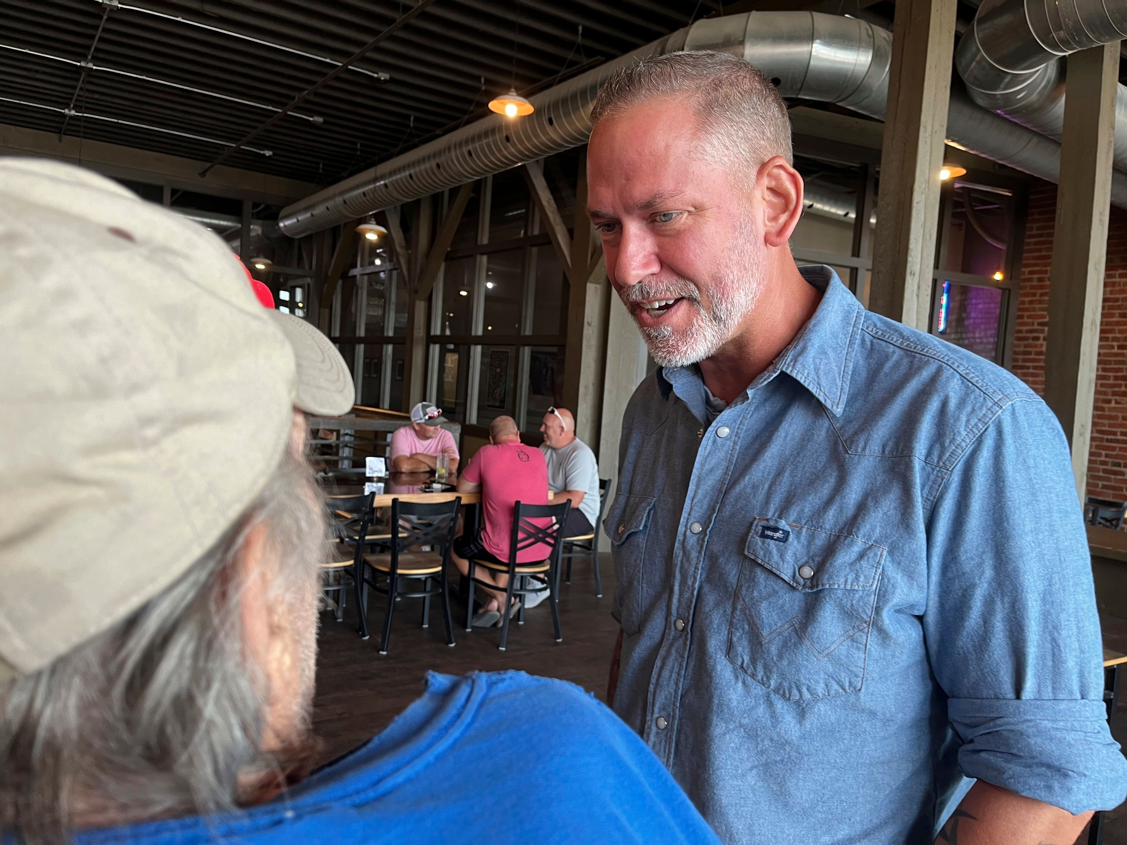 Independent Dan Osborn, a challenger to two-term Republican Sen. Deb Fischer, chats with patrons of a brewery in Beatrice, Neb., July 30, 2024. (AP Photo/Margery Beck)