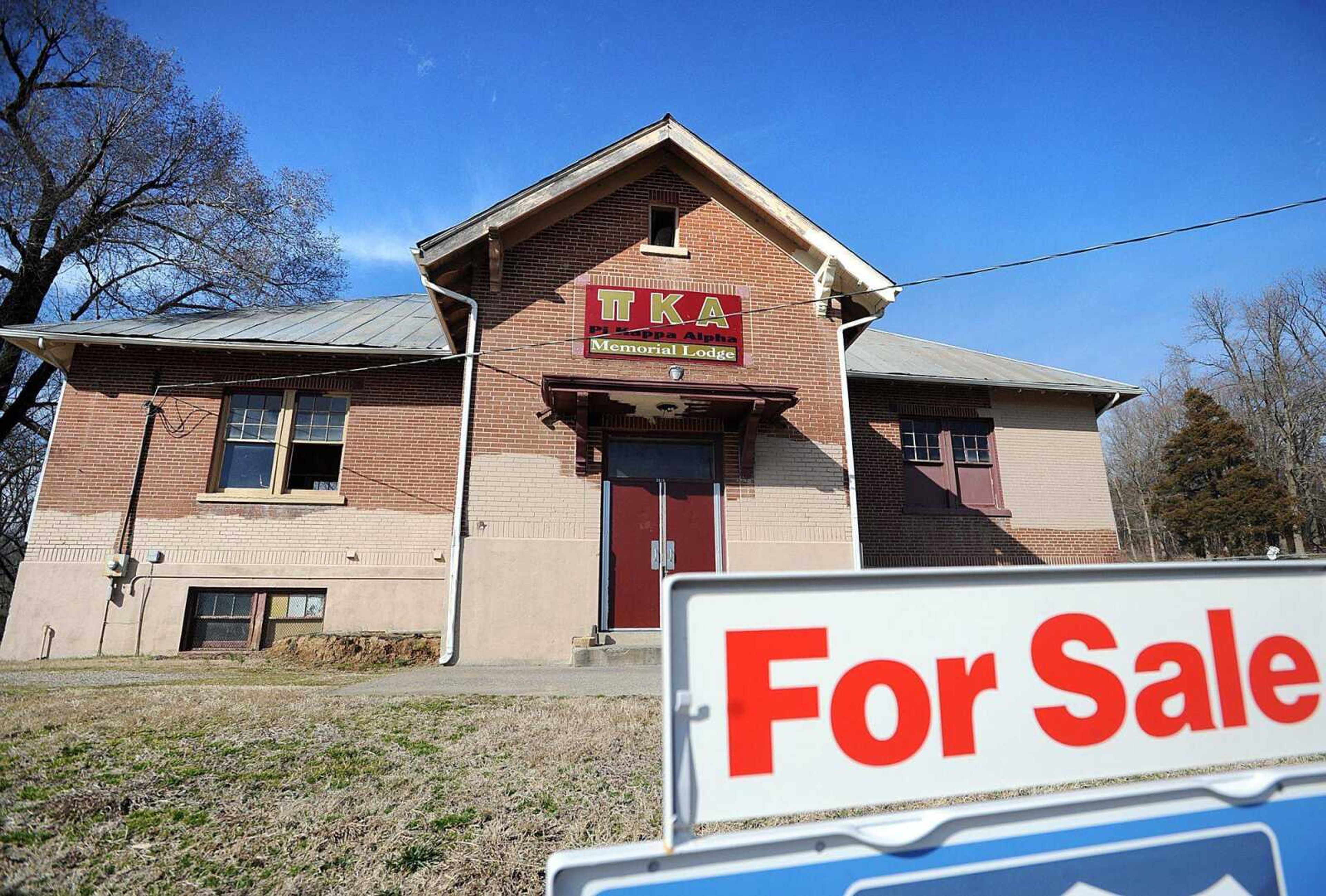 A For Sale sign sits in front of the Pi Kappa Alpha Memorial Lodge on S. Sprigg Street in Cape Girardeau. (Laura Simon)