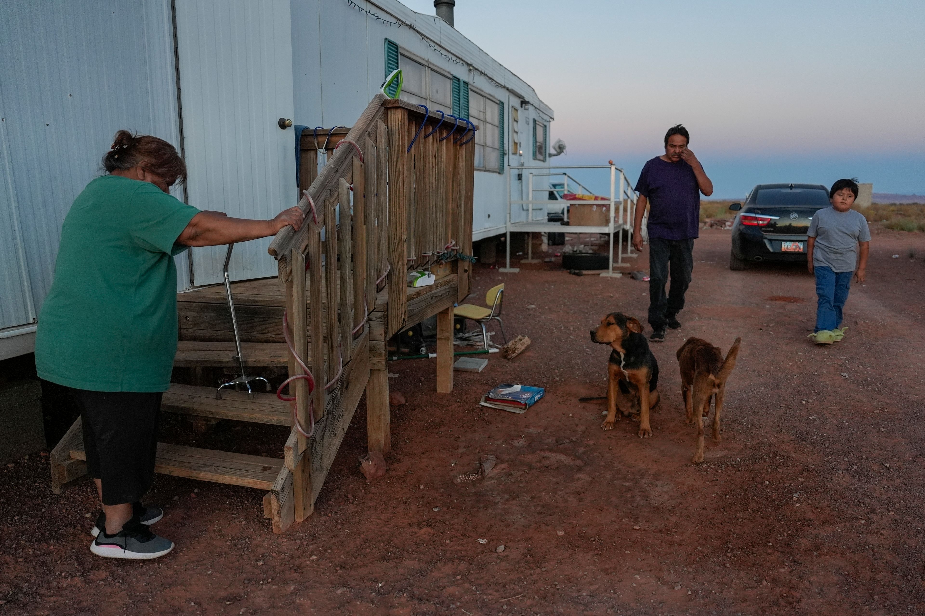 Lorraine Black, left, along with her husband, Ricky Gillis, center, and grandson, Liam Gillis, 7, walk outside their home, Wednesday, Oct. 9, 2024, on the Navajo Nation in Halchita, Utah. (AP Photo/Joshua A. Bickel)