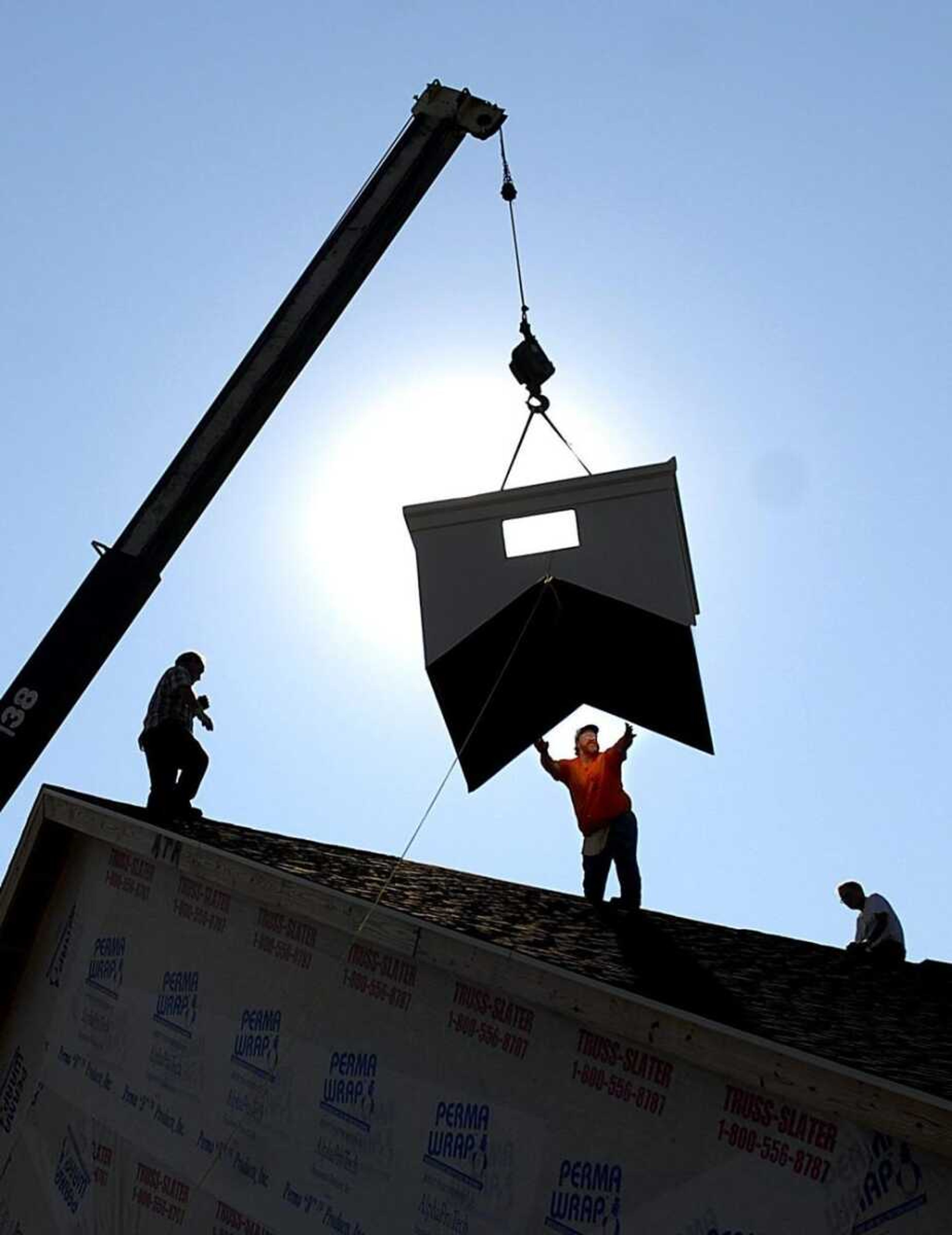 Kevin Clifton grabbed the base for the steeple as it was hoisted onto the roof of the new Bethlehem Baptist Church building Friday in Crosstown, Mo. The old Bethlehem Baptist Church was destroyed when a tornado passed through the town a year ago. (AARON EISEHAUER ~ aeisenhauer@semissourian.com)