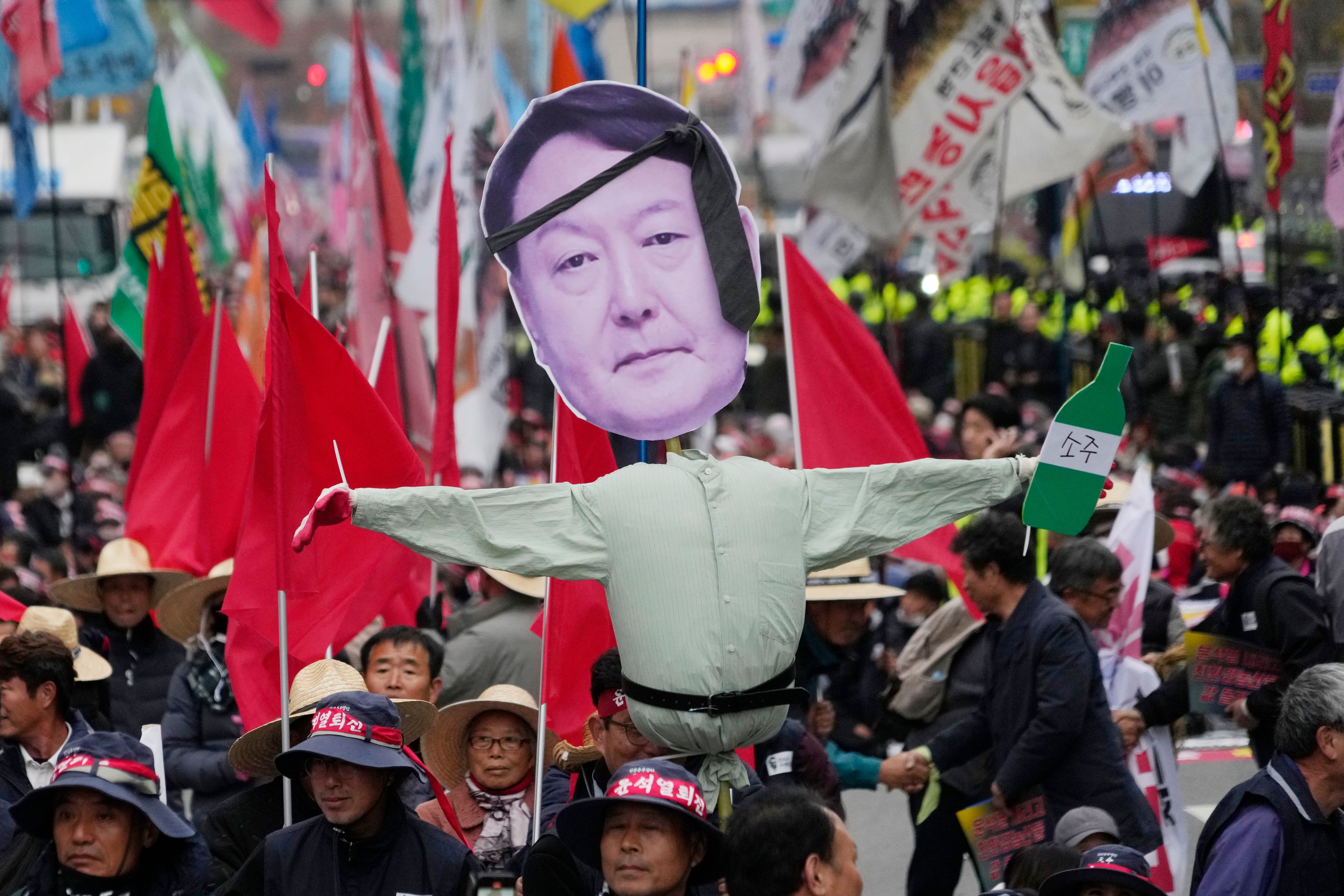 Members of the national federation of farmers, known as "Junnong," and the Korean Confederation of Trade Unions, march with an effigy of South Korean President Yoon Suk Yeol during a rally to demand the suspension of rice imports and Yoon's resignation in Seoul, South Korea, Wednesday, Nov. 20, 2024. (AP Photo/Ahn Young-joon)