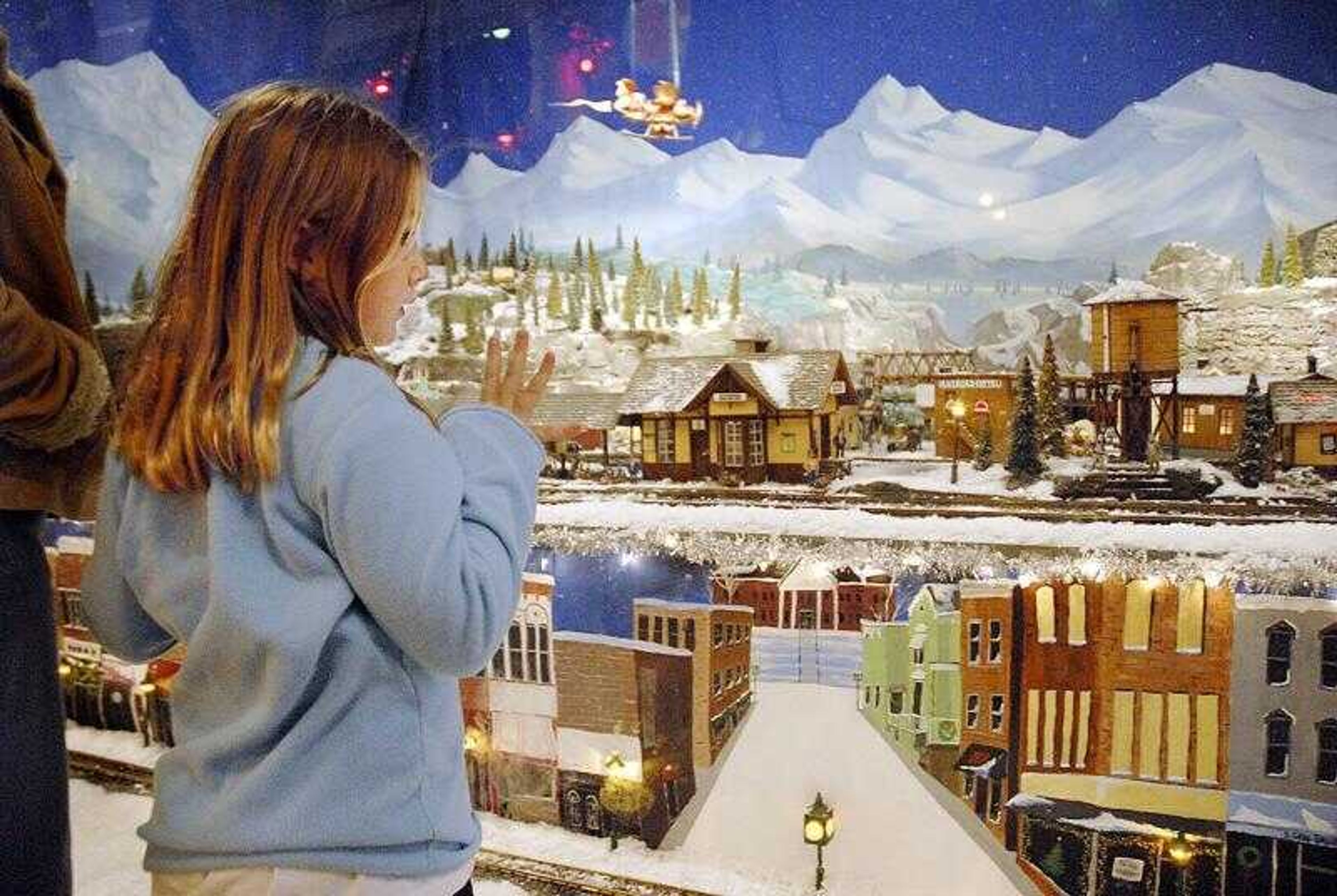 Tessa Allee, 7, pressed against the window of Hutson's Fine Furniture in downtown Cape Girardeau on Friday. Tessa came to watch the miniature trains buzz by with her parents, Clifton and Sue Allee of Cape Girardeau. (AARON EISENHAUER ~ photos@semissourian.com)