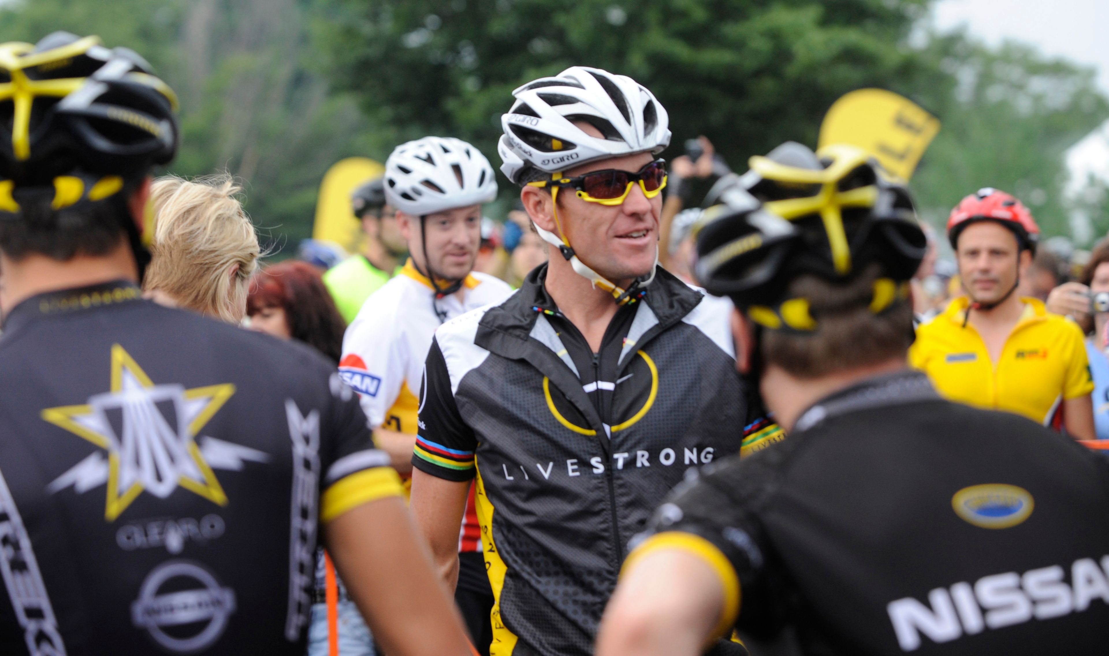 Cyclist Lance Armstrong, center, greets fellow riders prior to the start of his Livestrong Challenge 10K ride for cancer Sunday, Aug. 22, 2010 in Blue Bell, Pa. Armstrong was formally stripped of his seven Tour de France victories Oct. 22, 2012.