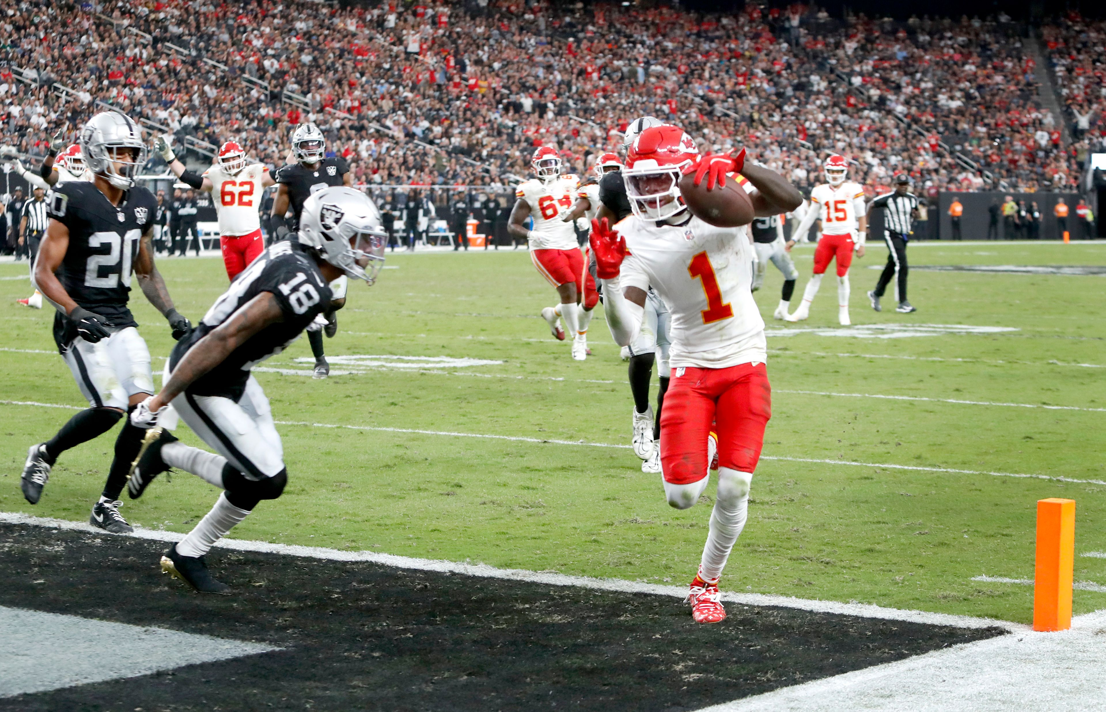 Kansas City Chiefs wide receiver Xavier Worthy (1) gets past Las Vegas Raiders cornerback Jack Jones (18) to score a touchdown during the second half of an NFL football game Sunday, Oct. 27, 2024, in Las Vegas. (Steve Marcus/Las Vegas Sun via AP)