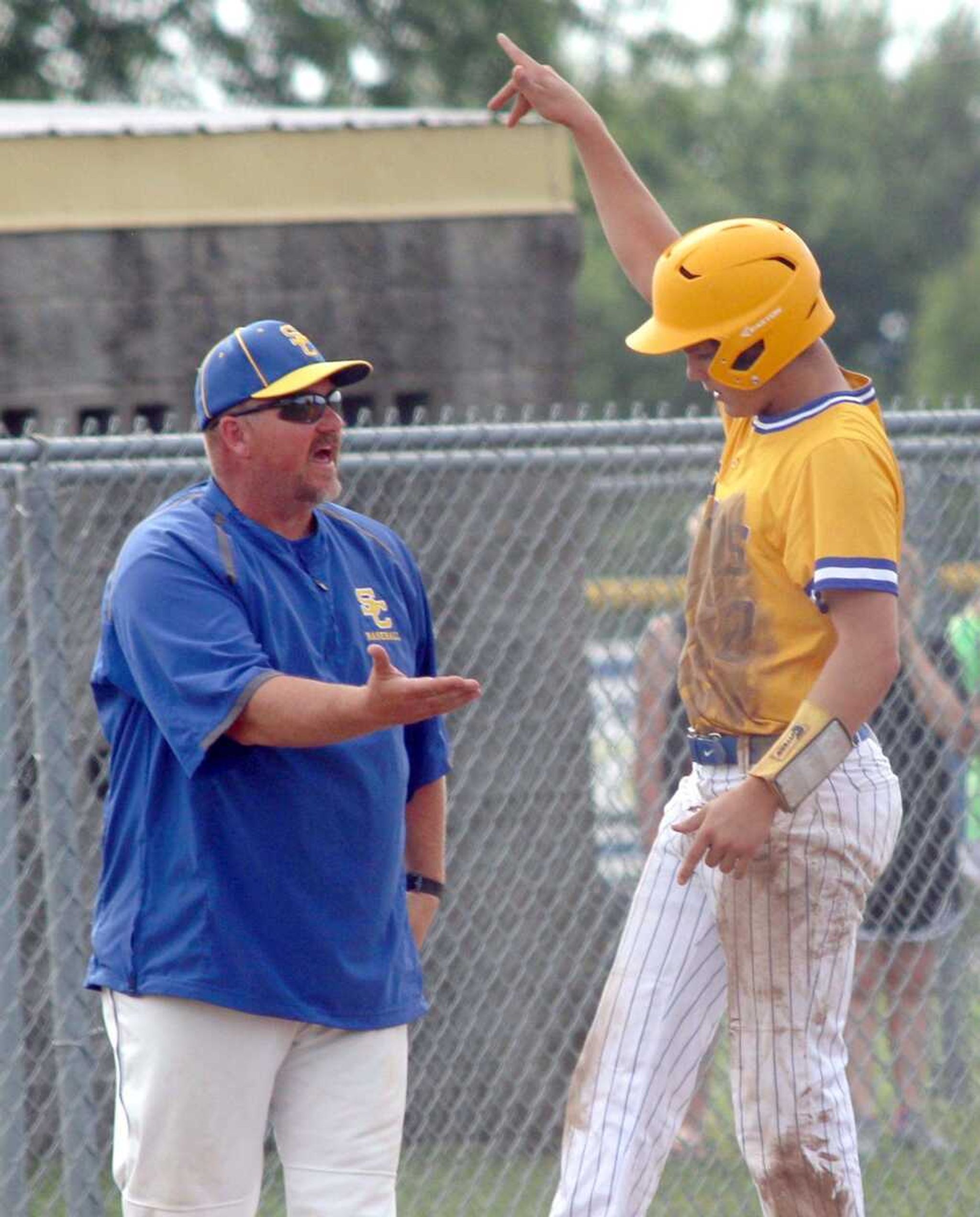 Scott City coach Jim May (left) greets Jordan Kluesner (right) at third base against New Madrid County Central Monday, May 23, 2016, during a Class 3 sectional baseball game at Scott City High School in Scott City, Mo. (Chris Pobst/Standard Democrat)