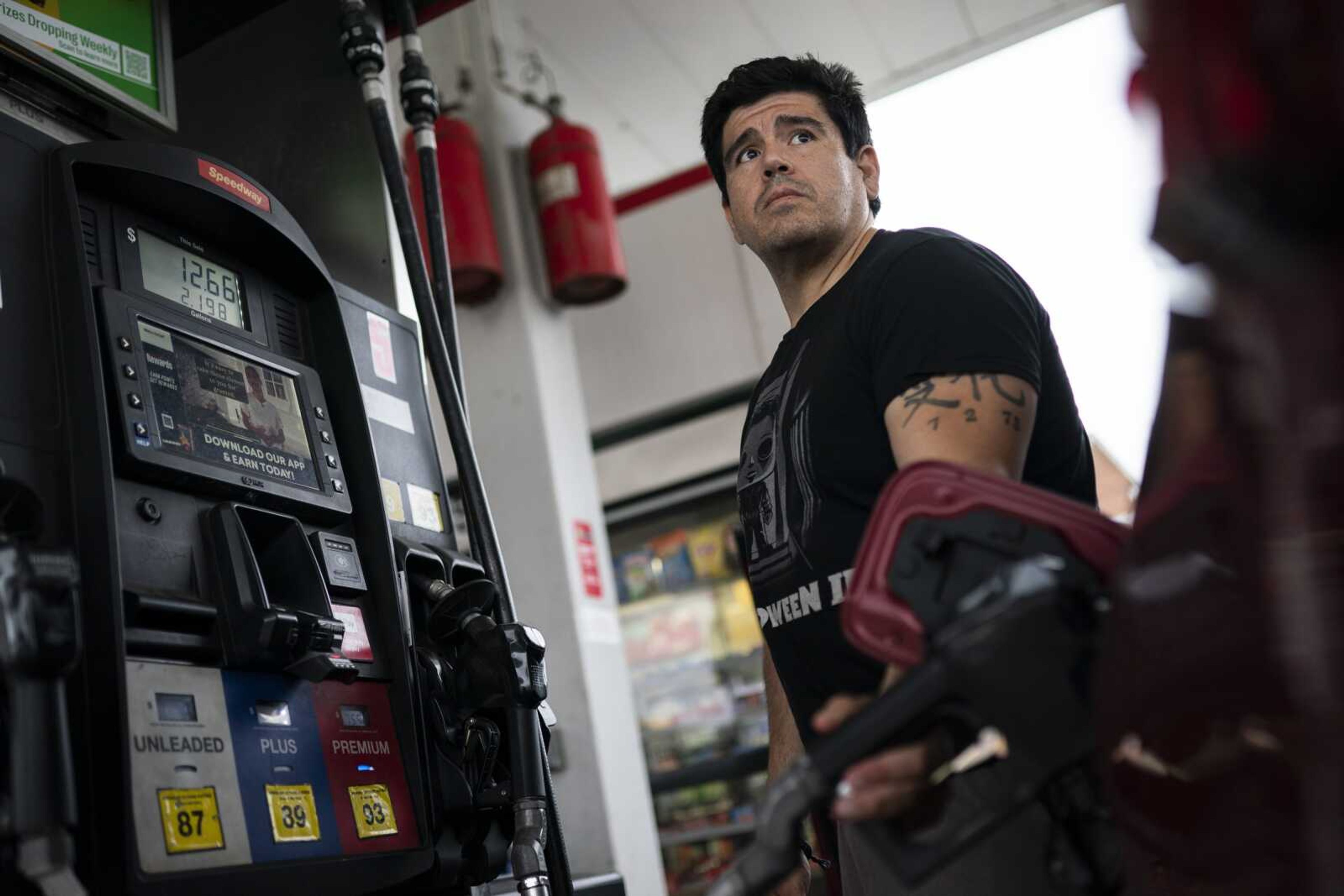 Wallace Reid fuels his vehicle he drives to make a living using ride-hail apps, Wednesday in the Queens borough of New York. Millions of Americans who rely on their cars for work are changing their habits, signing up for carpools or even ditching their cars for bicycles as gas prices recently hit $5 per gallon for the first time ever.