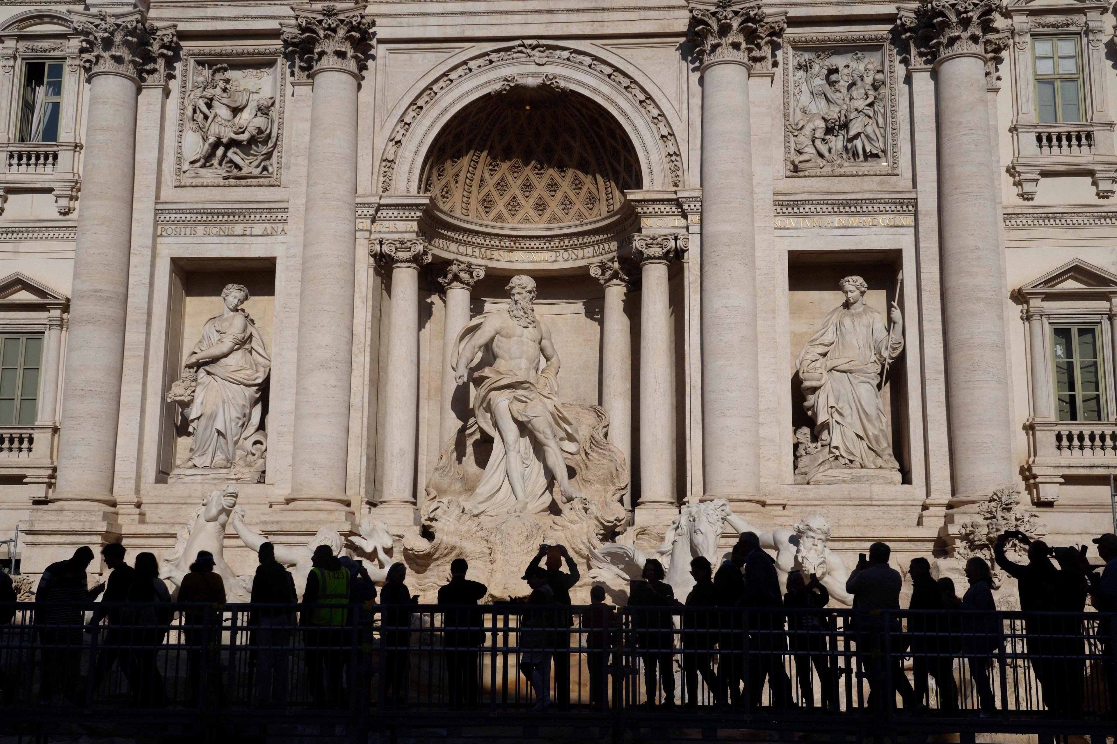 People walk along an elevated walkway in Rome, Tuesday, Nov. 12, 2024, that gives limited access to the Trevi Fountain monument during maintenance work. (AP Photo/Gregorio Borgia)