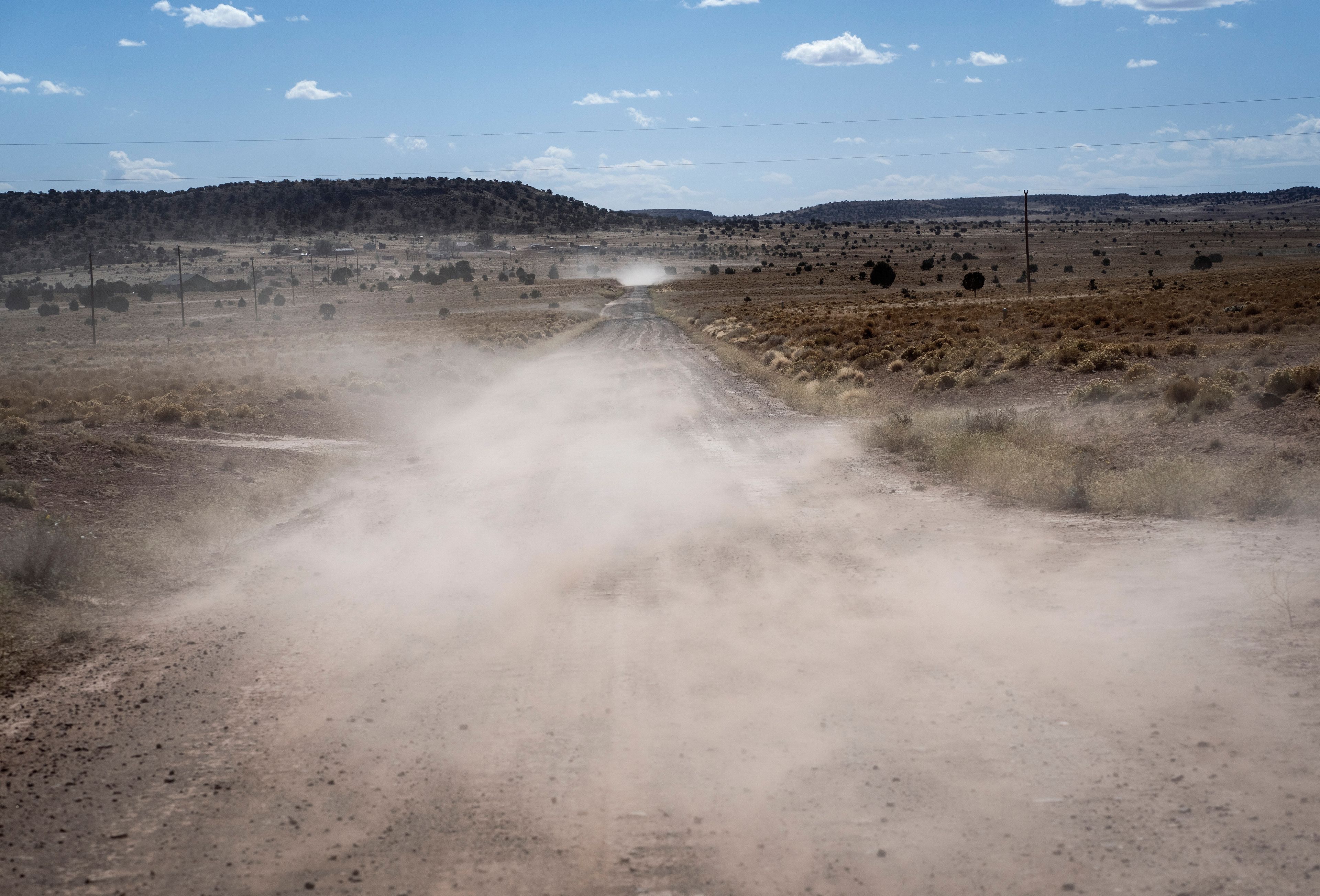 Dust rises across the road on a windy afternoon, on the Navajo Nation in Dilkon, Ariz., Wednesday, Oct. 16, 2024. (AP Photo/Rodrigo Abd)