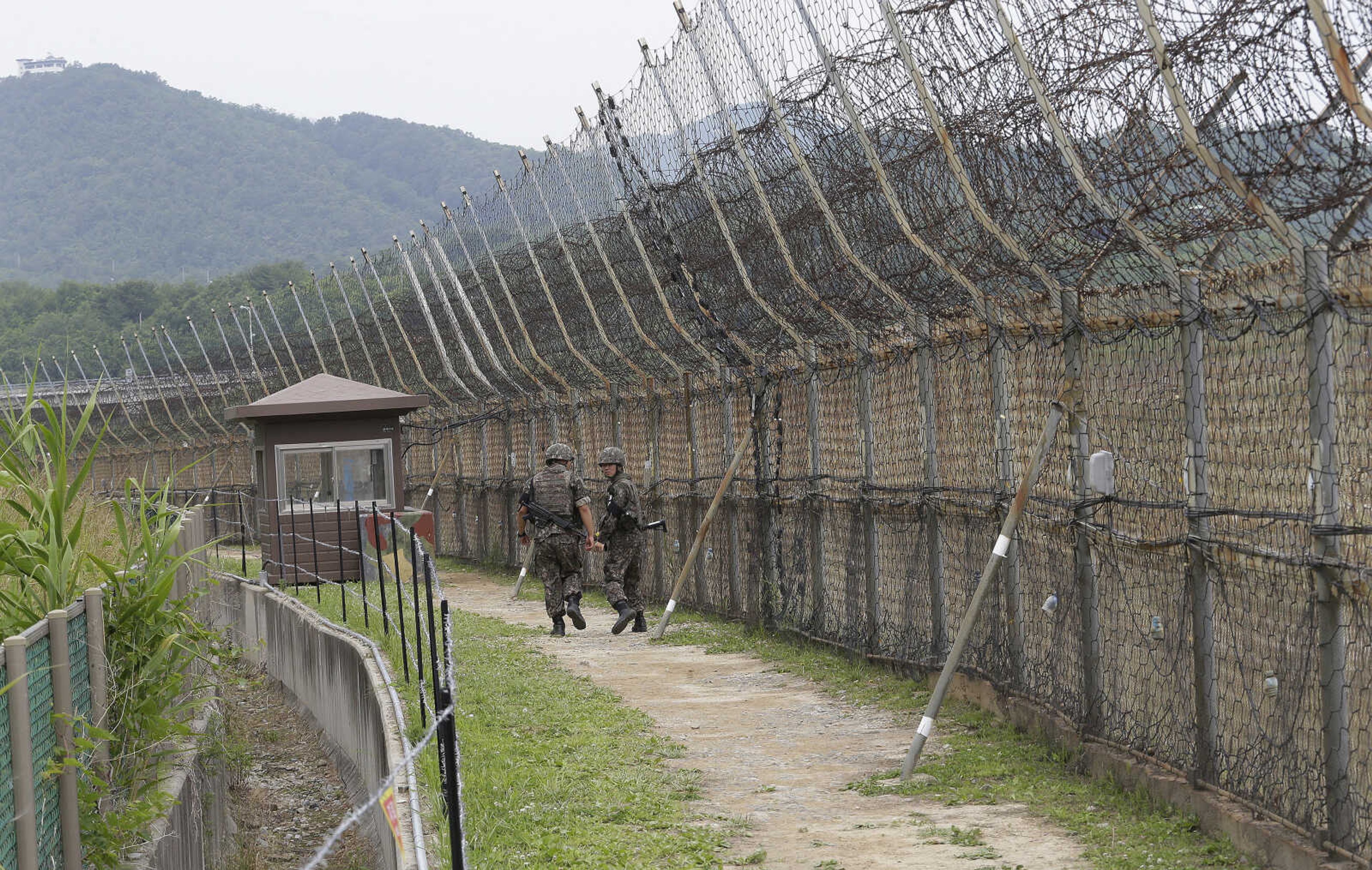 FILE - South Korean soldiers patrol while hikers visit the DMZ Peace Trail in the demilitarized zone in Goseong, South Korea, June 14, 2019. A series of low-slung buildings and somber soldiers dot the landscape of the DMZ, or demilitarized zone, the swath of land between North and South Korea where a soldier on a tour crossed into North Korea on Tuesday, July 18, 2023, under circumstances that remain unclear. (AP Photo/Ahn Young-joon, File)