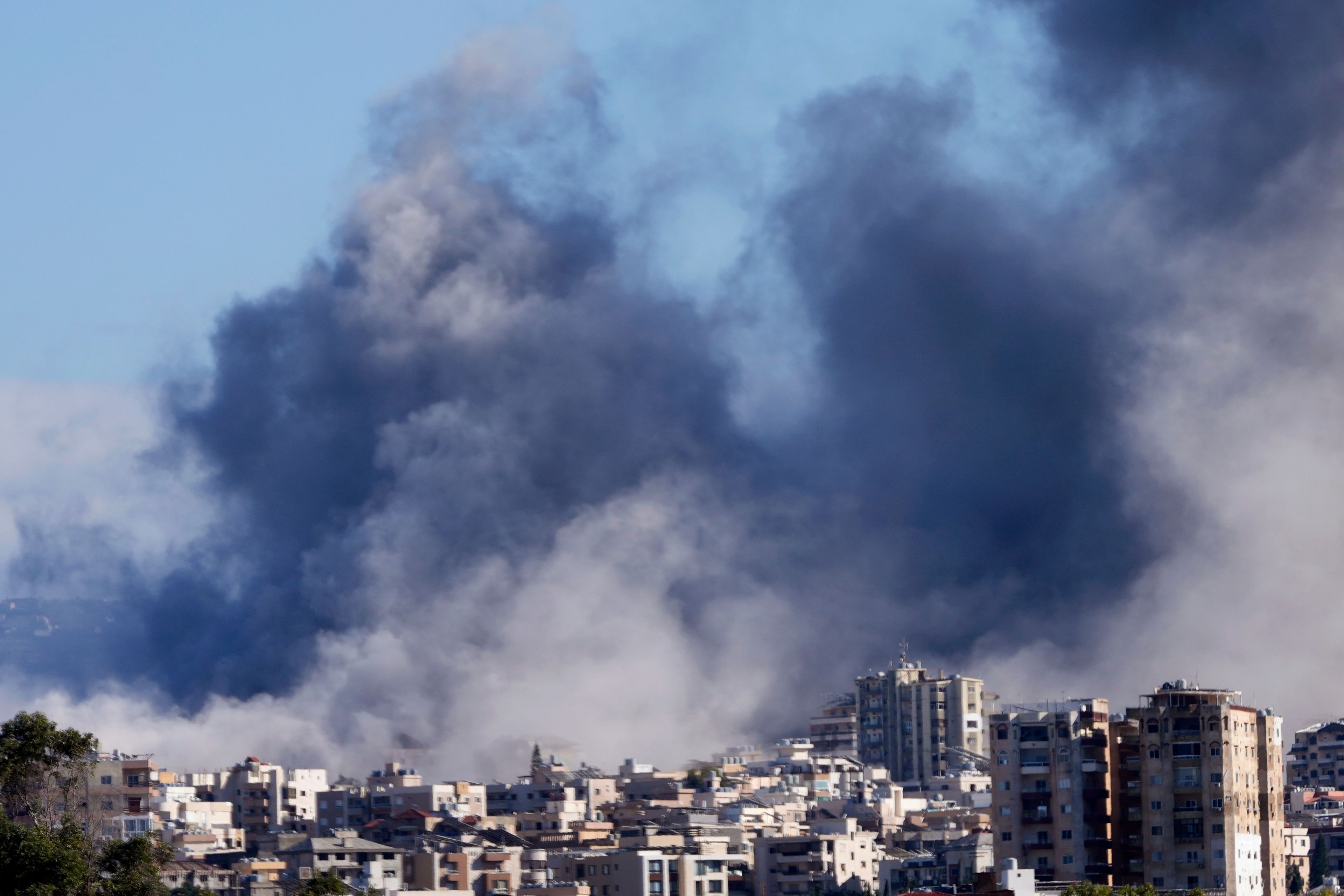 Smoke rises between buildings hit in Israeli airstrikes in Hosh neighbourhood, in Tyre, south Lebanon, Tuesday, Nov. 26, 2024. (AP Photo/Hussein Malla)