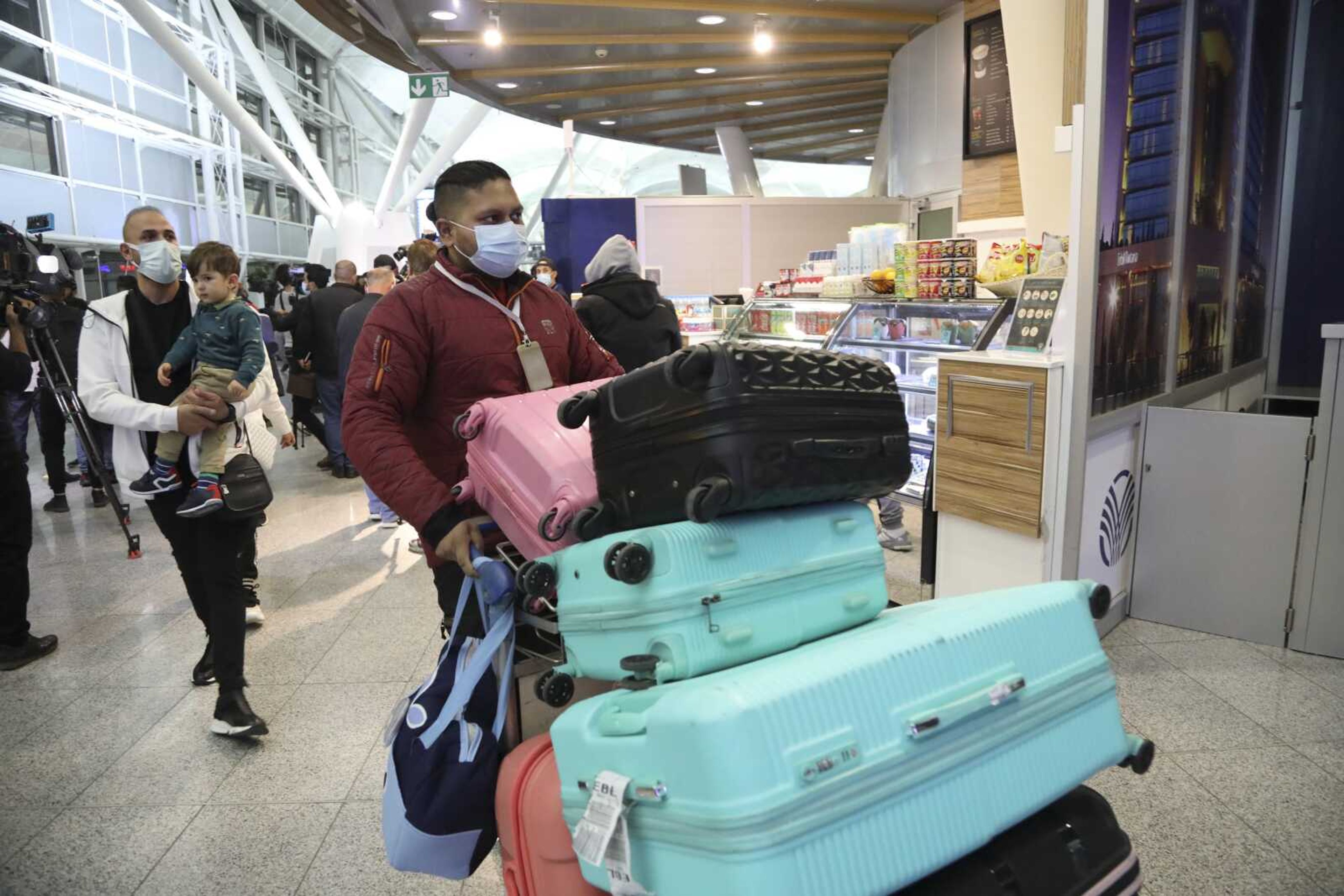 Iraqi migrants arrive to the airport Thursday in Irbil, Iraq.