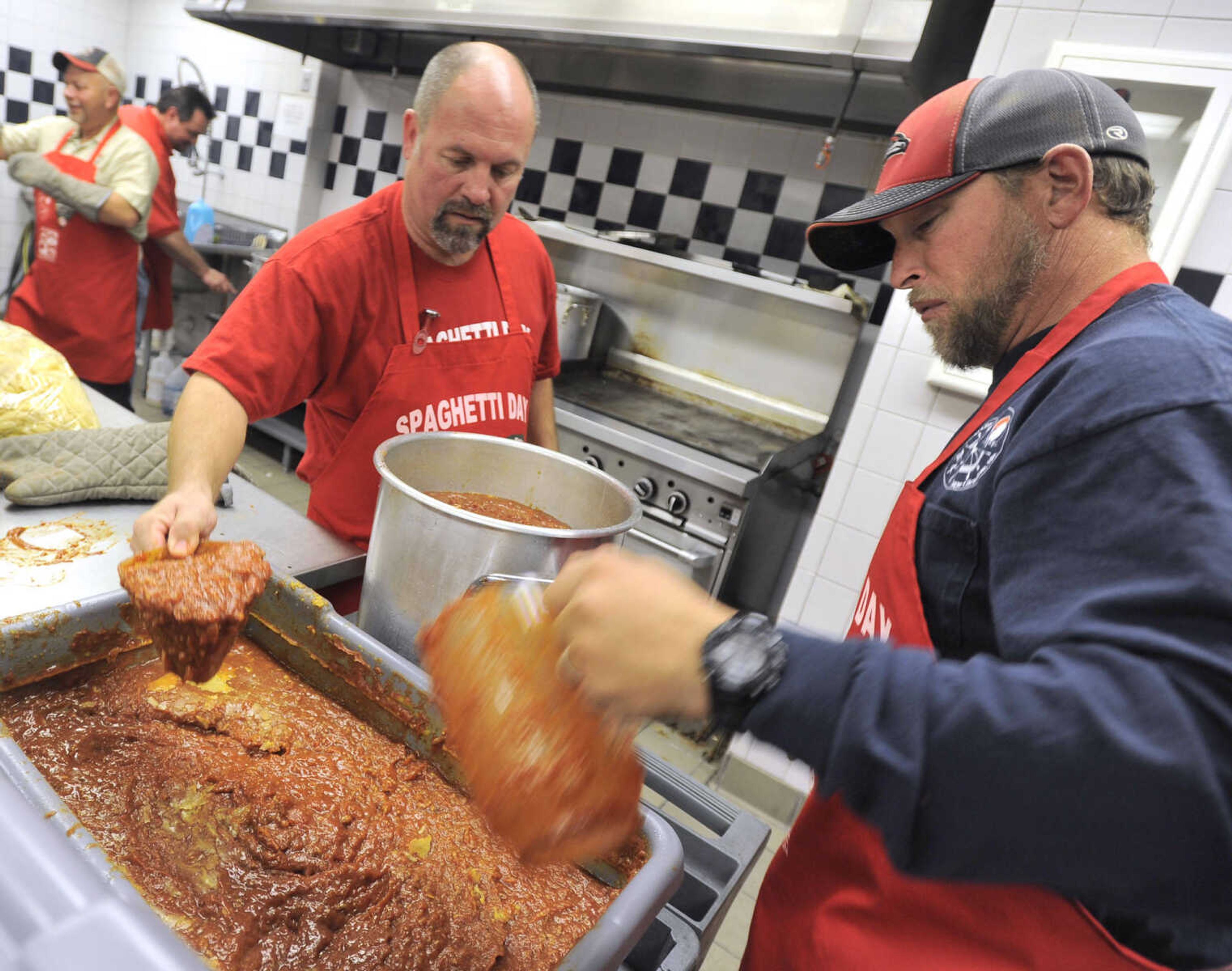 Tony Weatherby, left, and Rob Smithey scoop spaghetti sauce for the serving line at the Parks & Recreation Foundation Spaghetti Day Wednesday, Nov. 13, 2013 at the Arena Building.