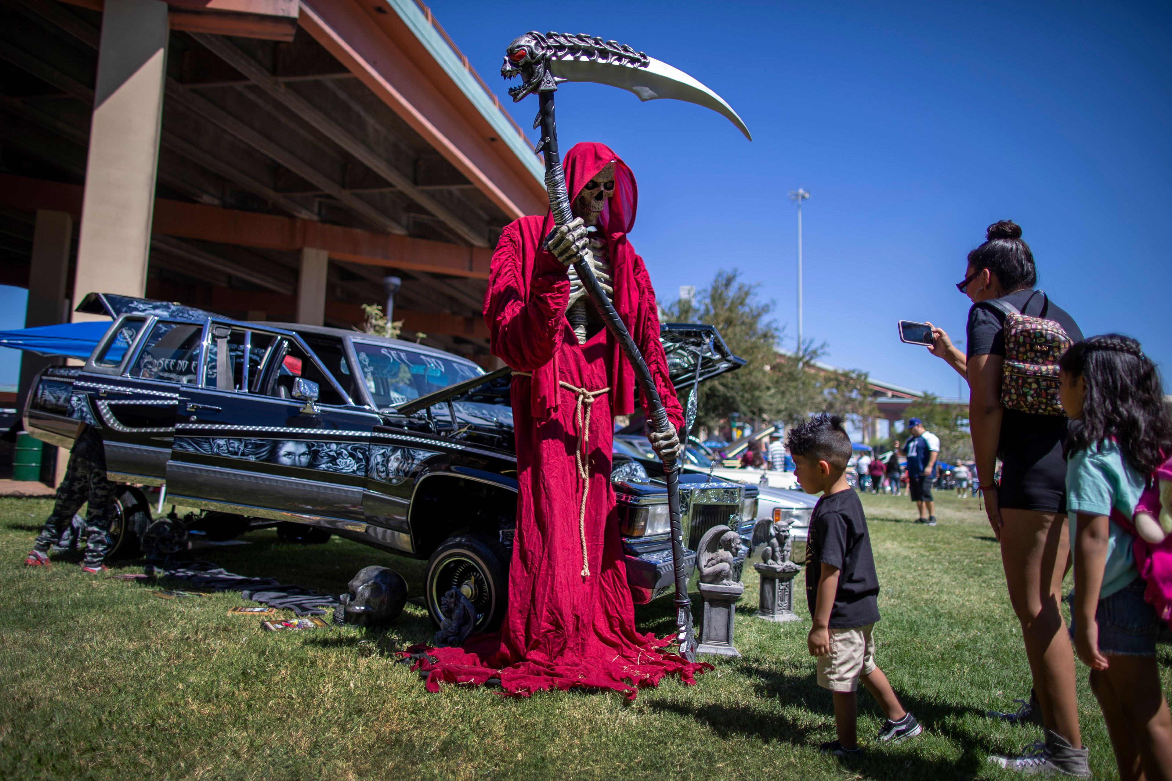 A family visits a vintage car during a lowrider exhibition for the 20th anniversary of Lincoln Park in El Paso, Texas, Sunday, Sept. 22, 2024. (AP Photo/Andrés Leighton)