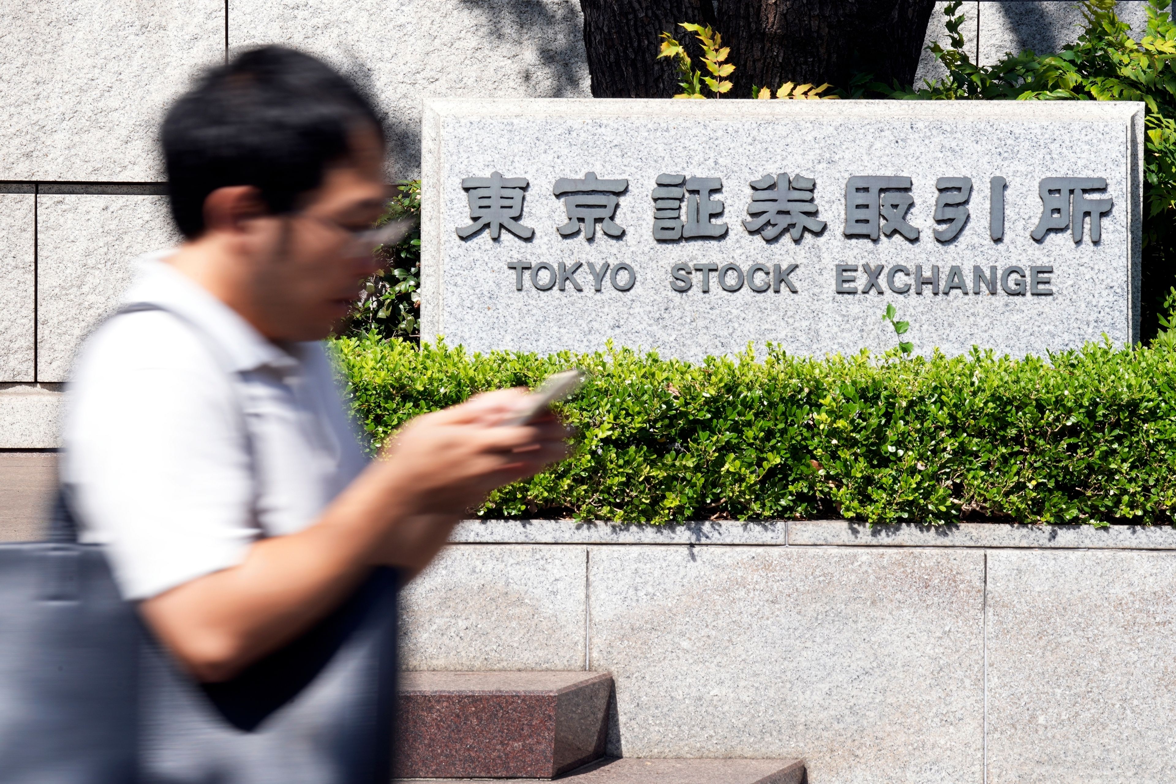 A person walks in front of the Tokyo Stock Exchange building Wednesday, Oct. 2, 2024, in Tokyo. (AP Photo/Eugene Hoshiko)