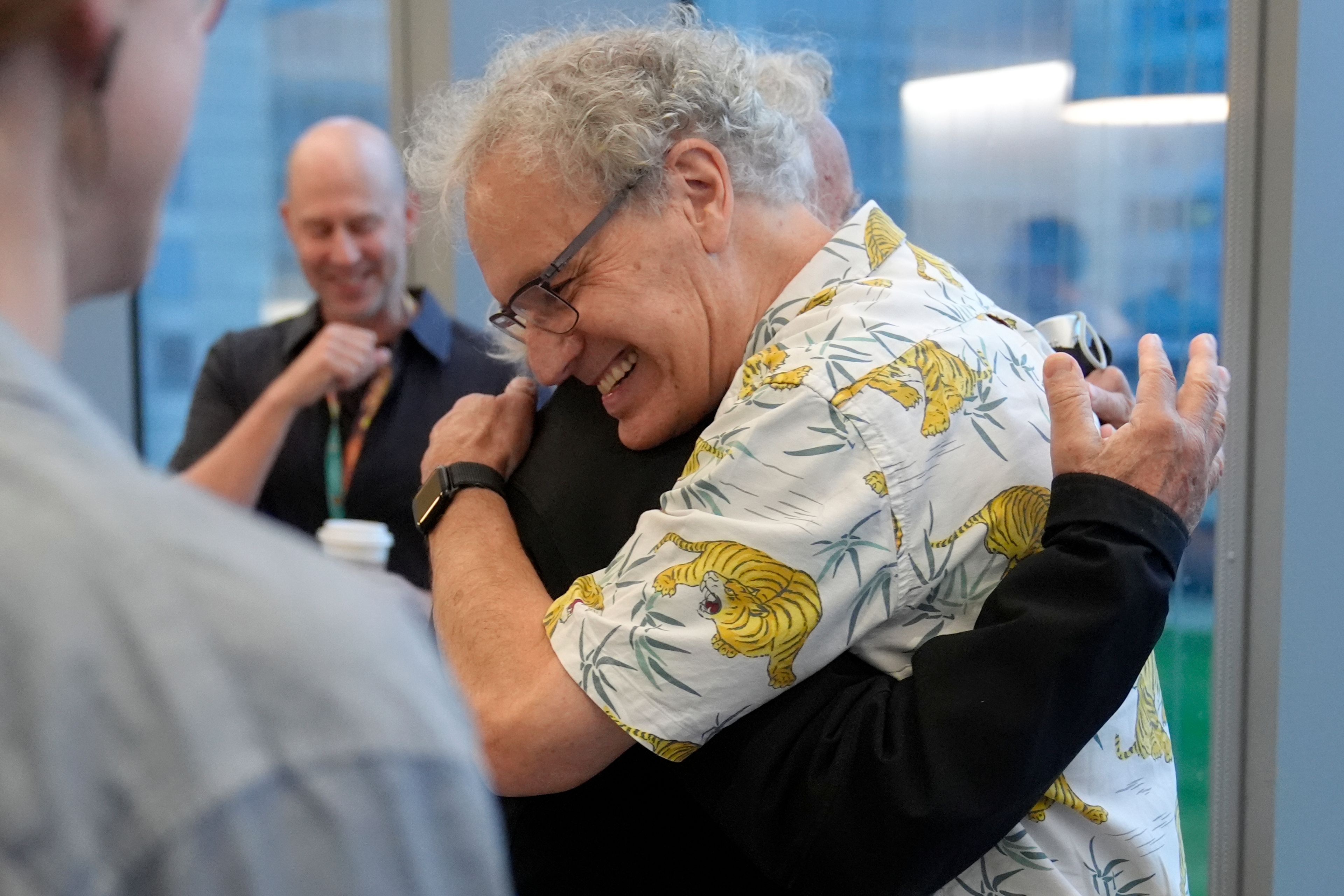 Victor Ambros, 2024 Nobel Prize winner in physiology or medicine, and professor of natural science at the University of Massachusetts Medical School, right, hugs colleague Allan Jacobson, at the school, in Worcester, Mass. Monday, Oct. 7, 2024. (AP Photo/Steven Senne)