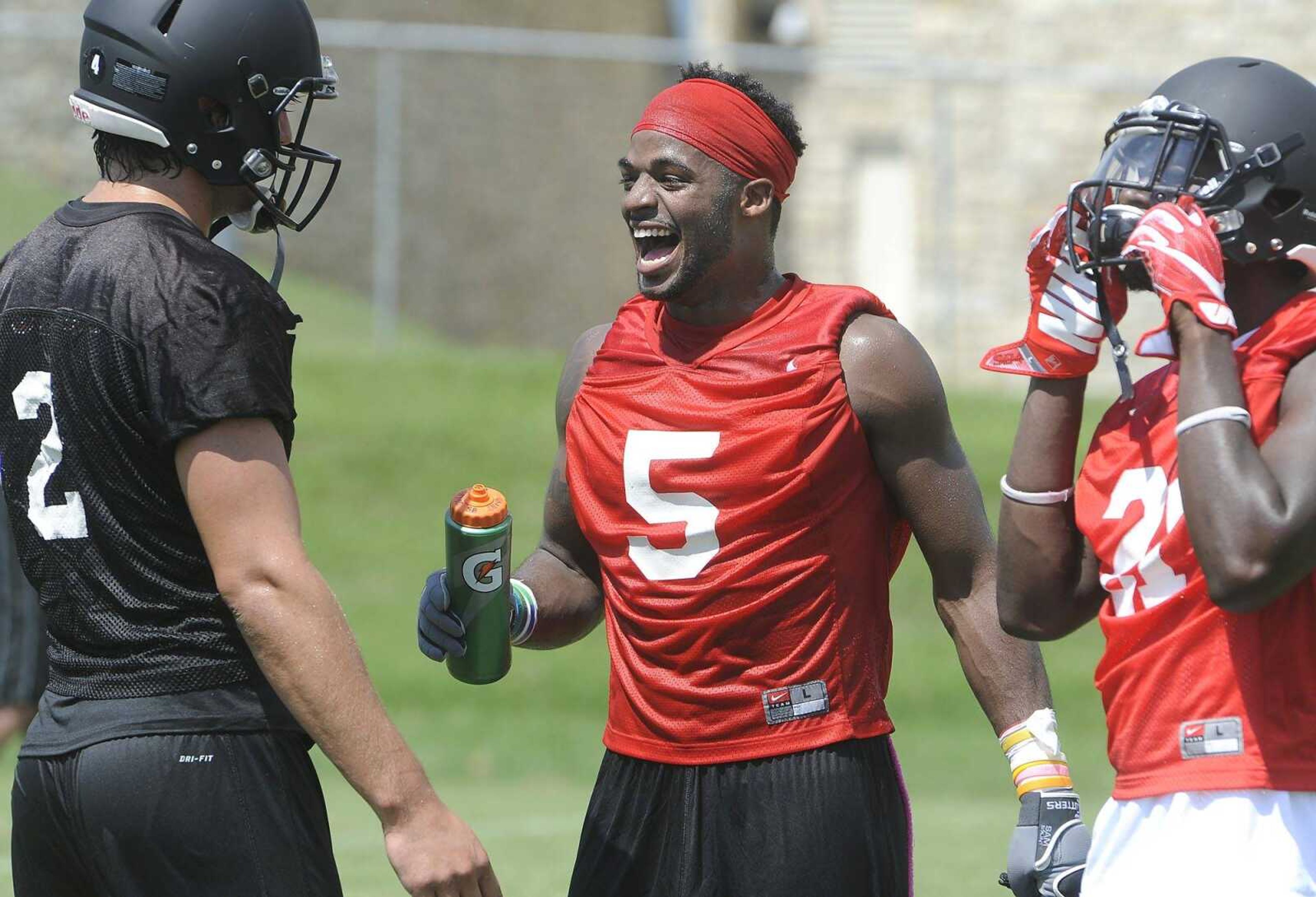 Southeast Missouri State's Eriq Moore, center, enjoys a water break Thursday, Aug. 4, 2016 while talking to number-two quarterback Jesse Hosket during the team's first official practice at Rosengarten Athletic Complex.