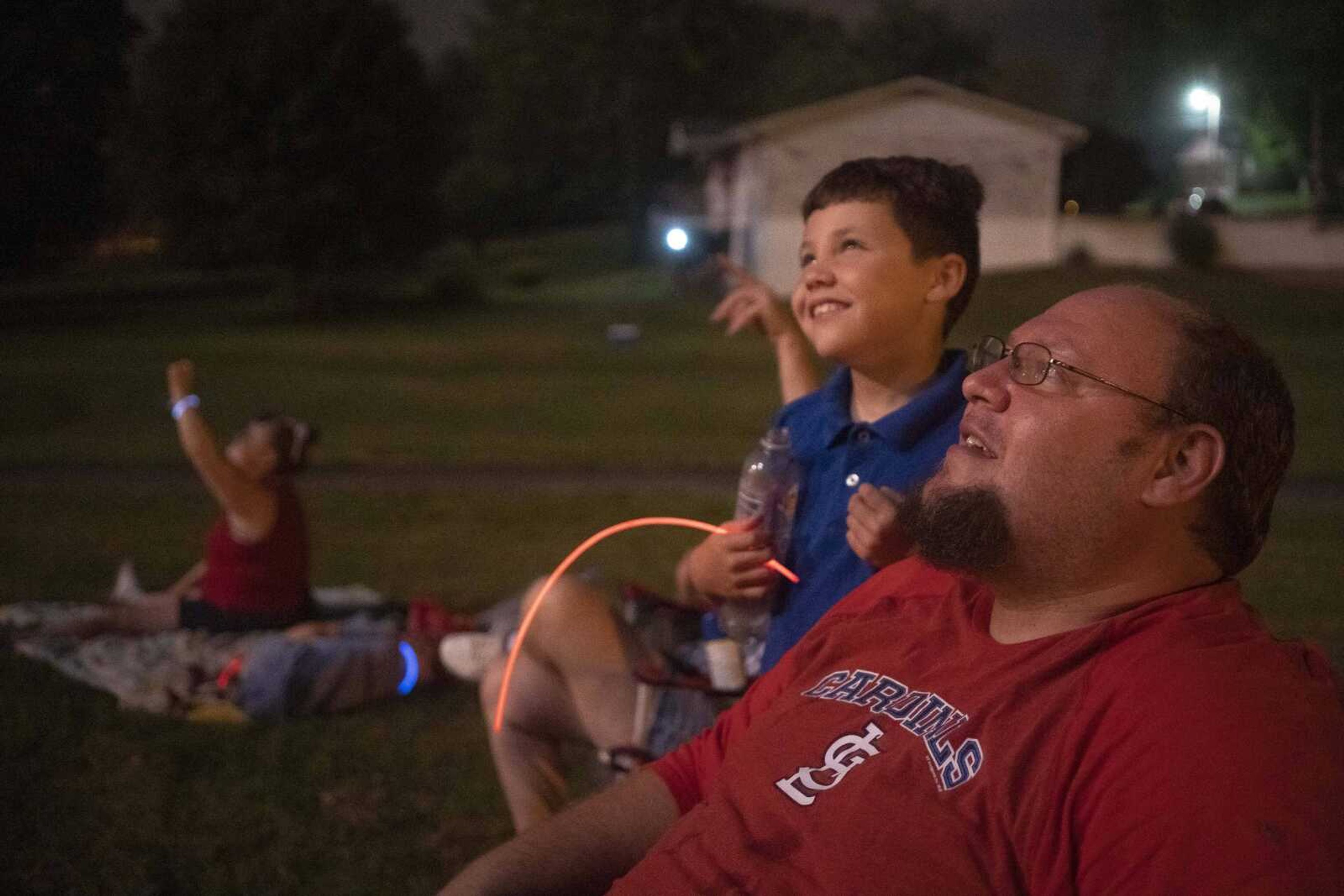 Josh Martin, right, watches a fireworks display with his nephew, Isaiah Dunavan, 9, and other family members during an Independence Day celebration at the Jackson Municipal Band Shell.