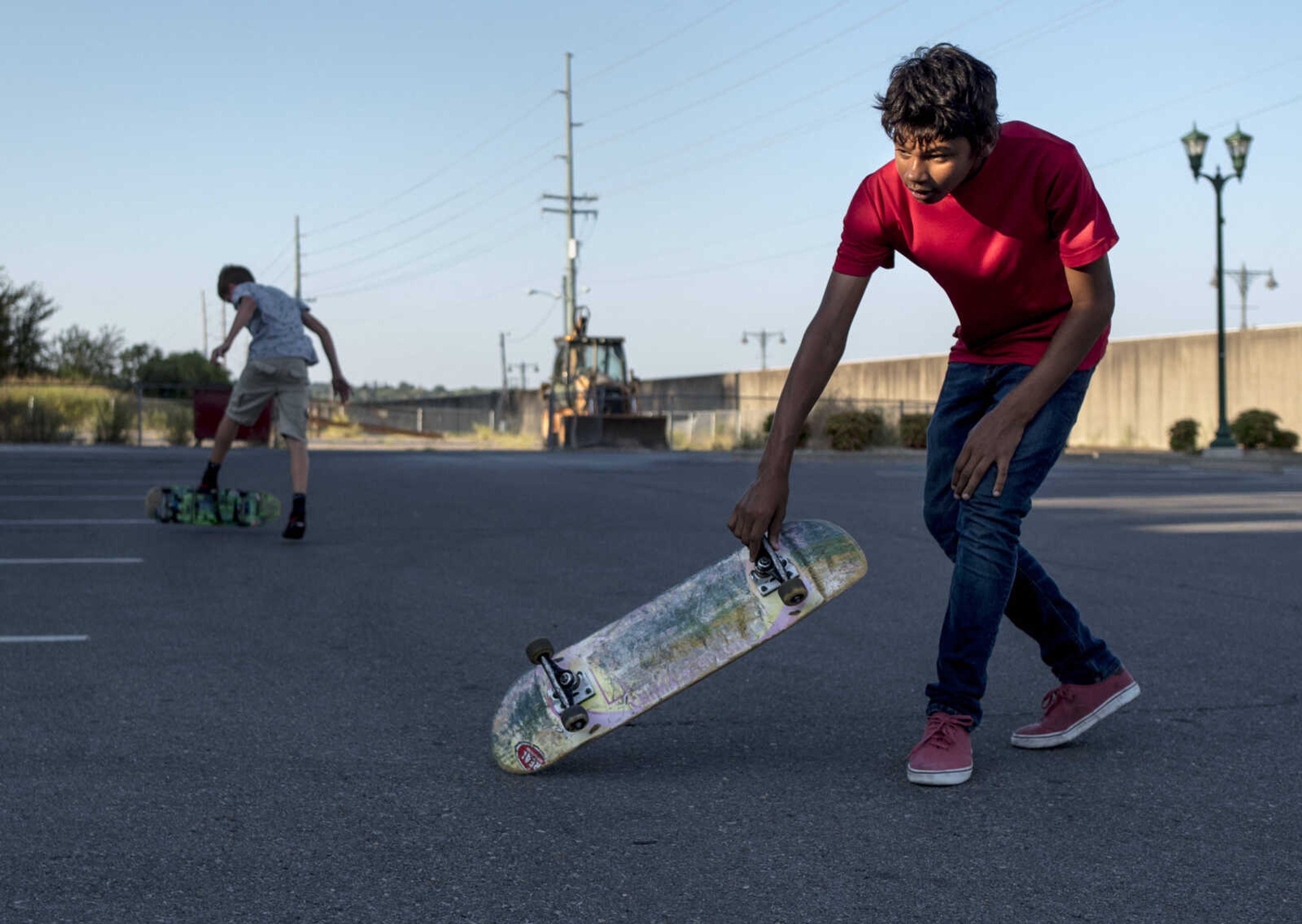 Marcus Pair, 12, picks up his Real skateboard deck as Elliot Allen, 12, left, catches his balance while skating Wednesday, Sept. 18, 2019, in a parking lot outside of Riverfront Park in Cape Girardeau. "You used to be able to see [the brand name]," Pair said with a laugh while describing his worn-in skateboard.