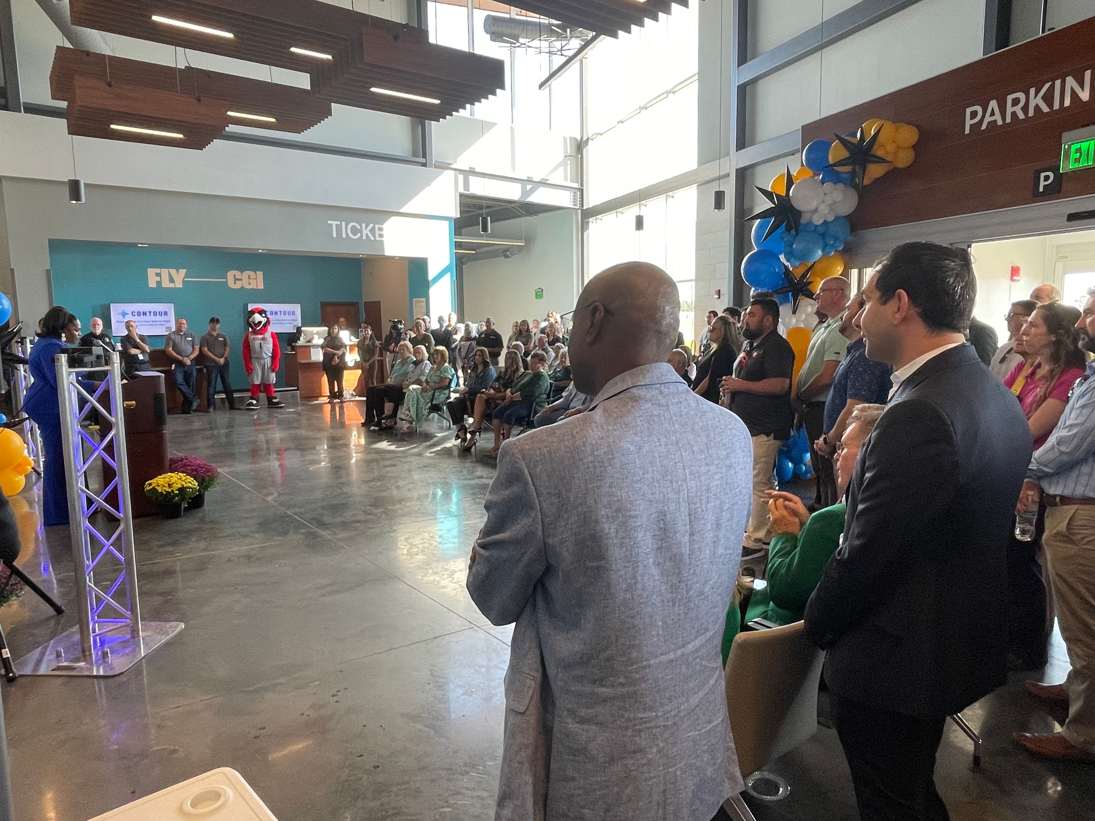 Katrina Amos, former airport director, talks to the crowd celebrating the launch of the new flights to Chicago. She thanked the former Cape Girardeau Mayor Bob Fox and current Mayor Stacy Kinder, as well as the airport board. Cape Girardeau city manager Kenneth Haskin, back to camera, and Contour CEO Matt Chaifetz listen to her remarks.