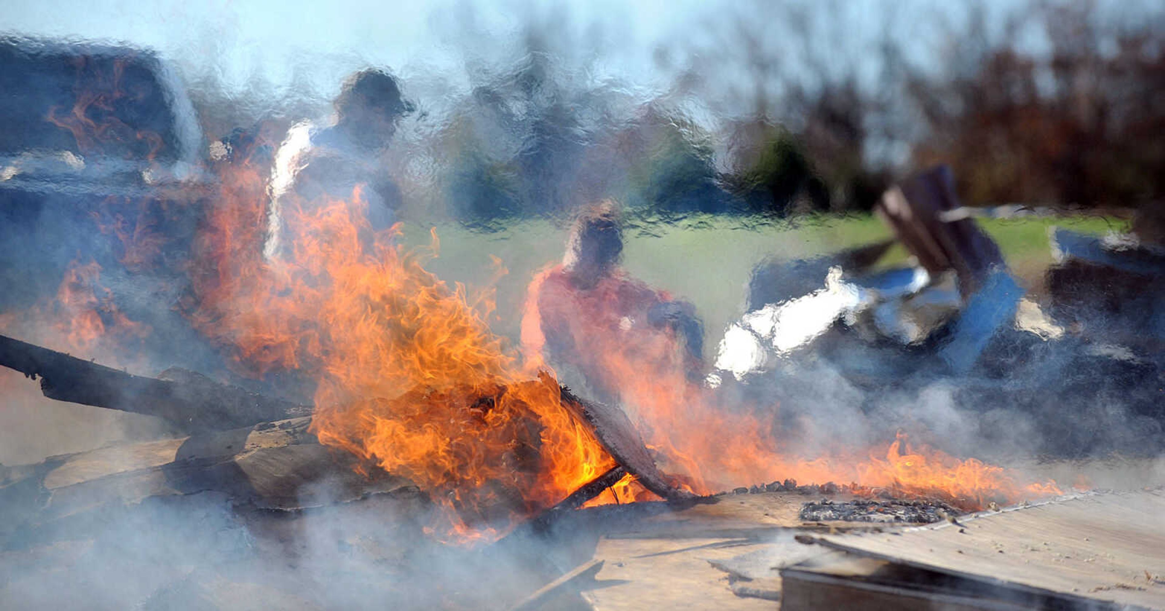 LAURA SIMON ~ lsimon@semissourian.com

Heat and smoke obscure Sharon Daniels, right and her son Thomas, as they burn the the remnants of her mobile home, Monday, Nov. 18, 2013, in Benton, Mo. Sharon Daniels recently purchased the mobile home near her family in a cul-de-sac off of Scott County Road 507. The mobile home moved around 20 feet off it's foundation during the severe weather that tore through the region on Sunday.