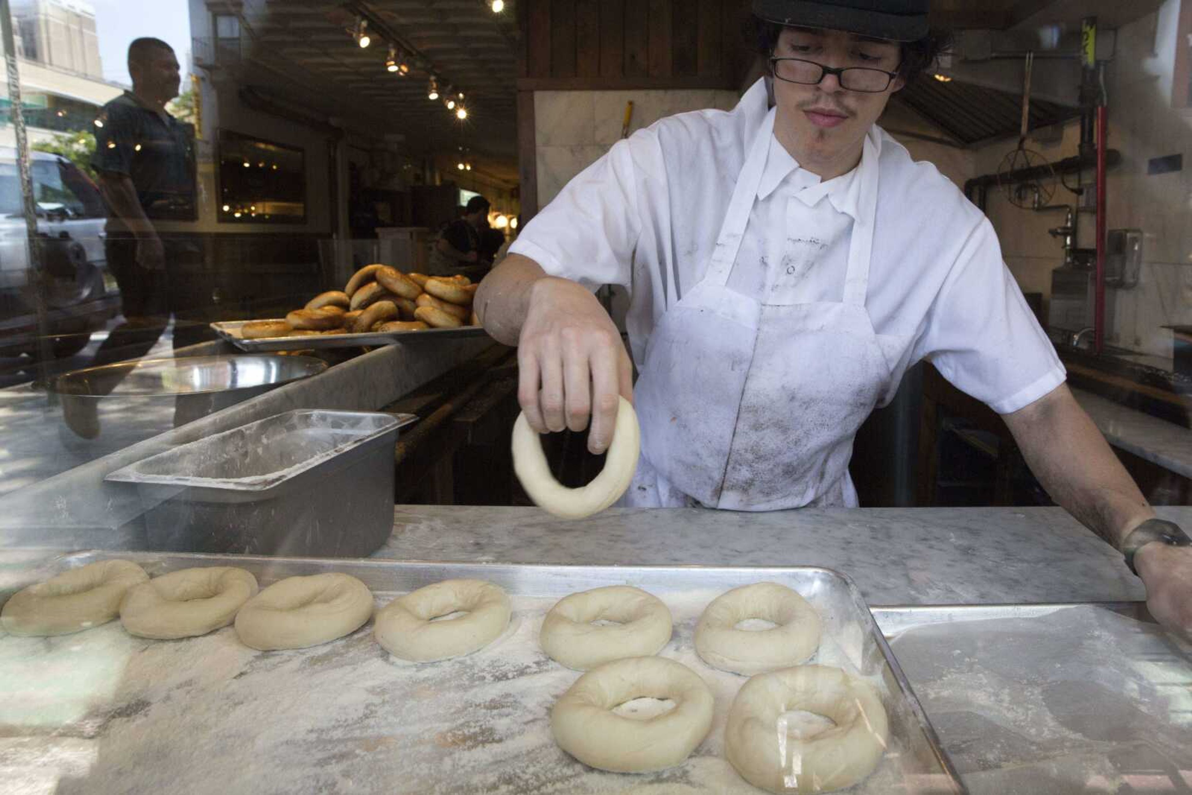 Baker Jefferson Arcila rolls dough into bagels at Black Seed bagel shop in the East Village neighborhood of New York on Friday, May 27. (AP Photo/Mary Altaffer)