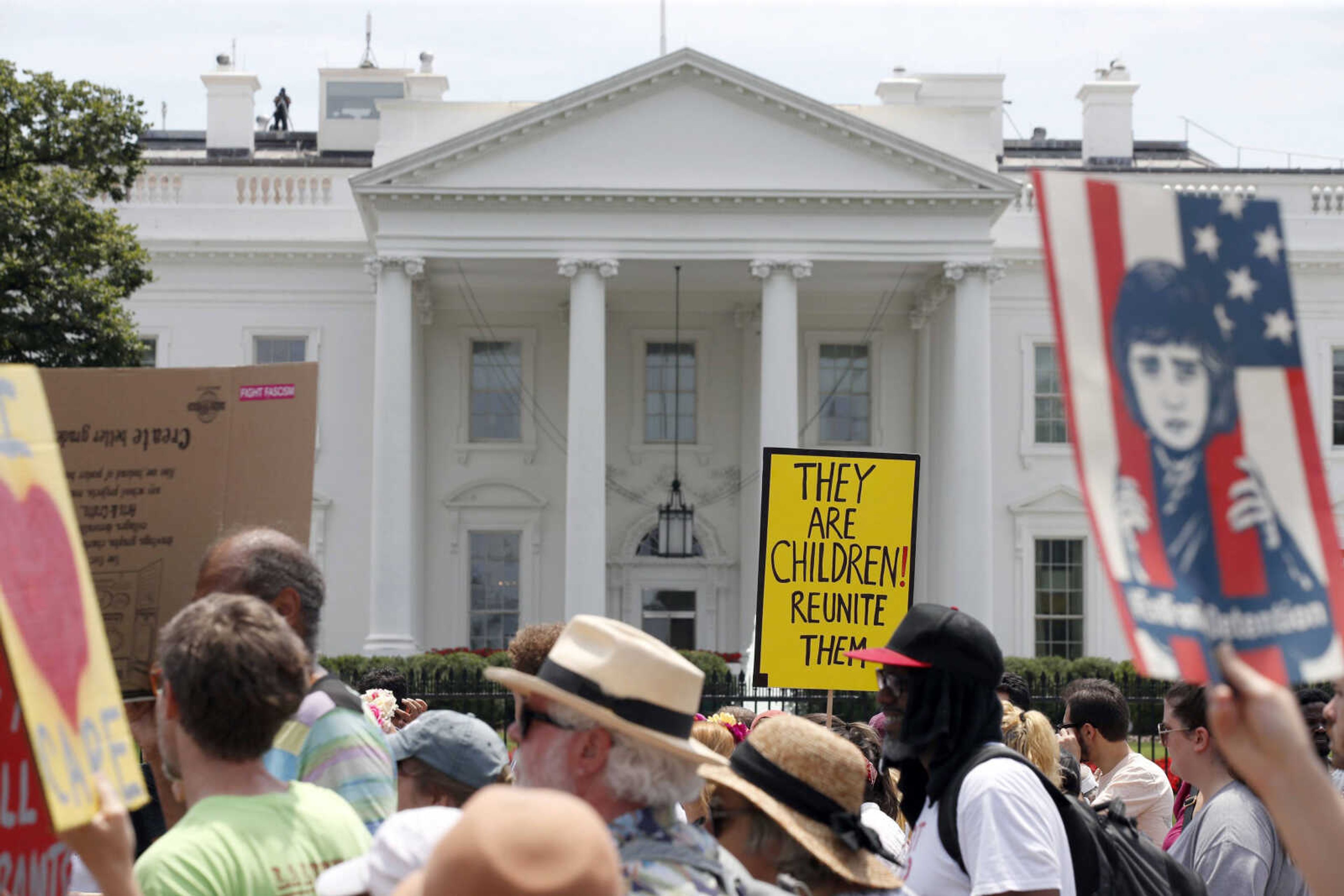 Activists march past the White House on Saturday to protest the Trump administration's approach to illegal border crossings and separation of children from immigrant parents in Washington.