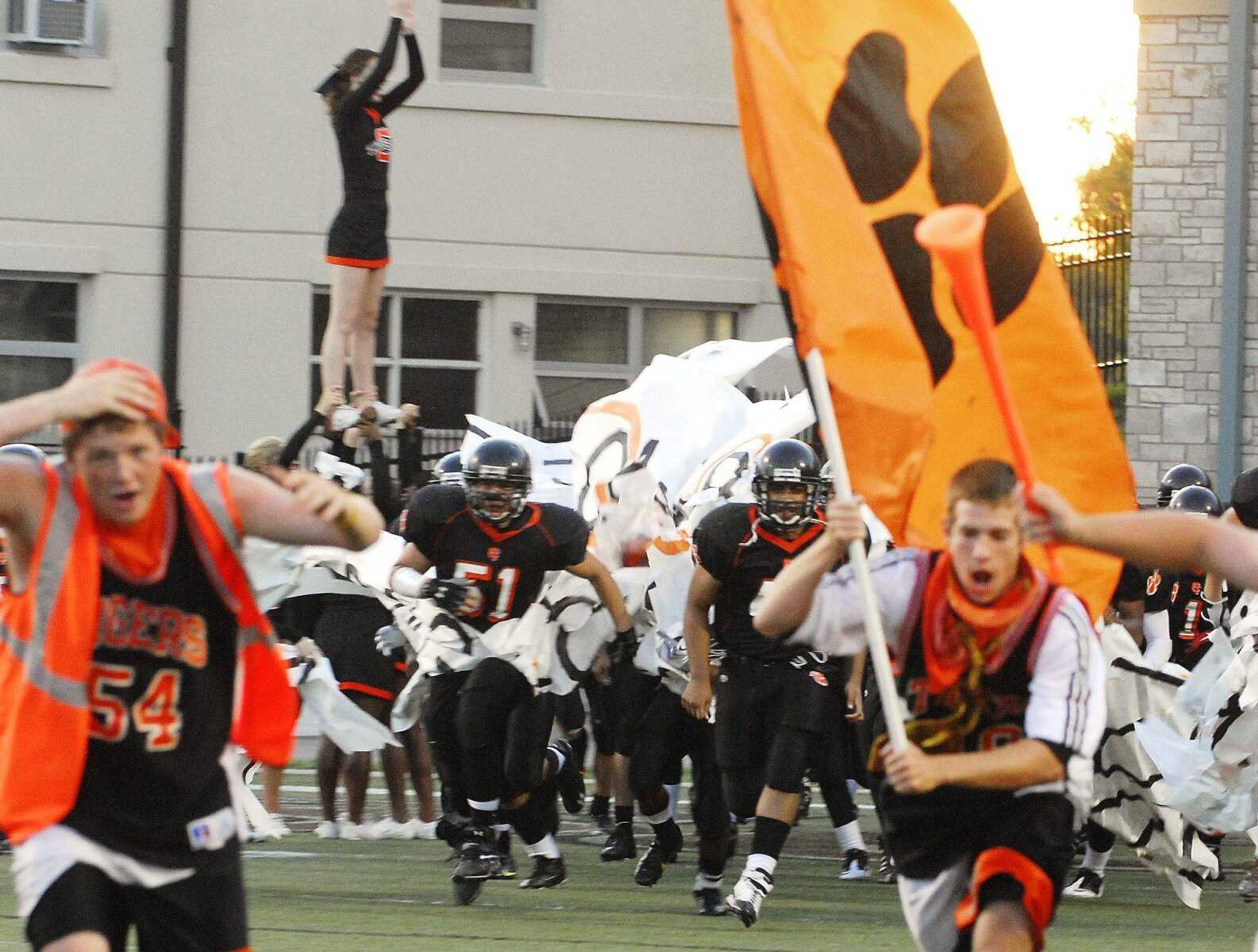 The Central Tigers break through a crowd of fans as they take the field Friday at Houck Stadium.